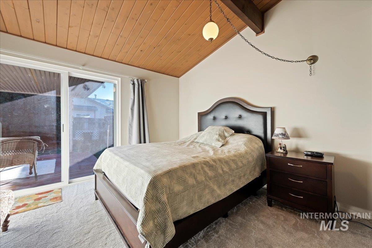 Carpeted bedroom with wood ceiling and access to exterior