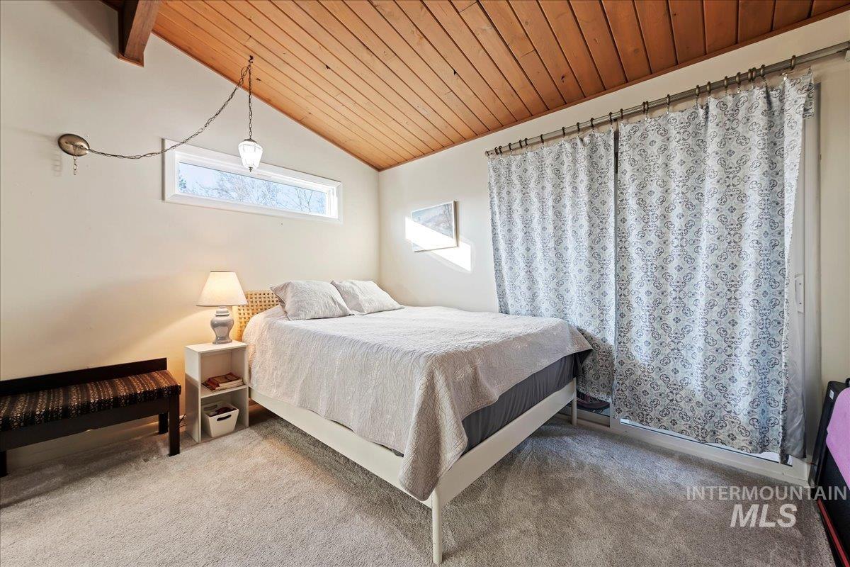Carpeted bedroom with wood ceiling and vaulted ceiling