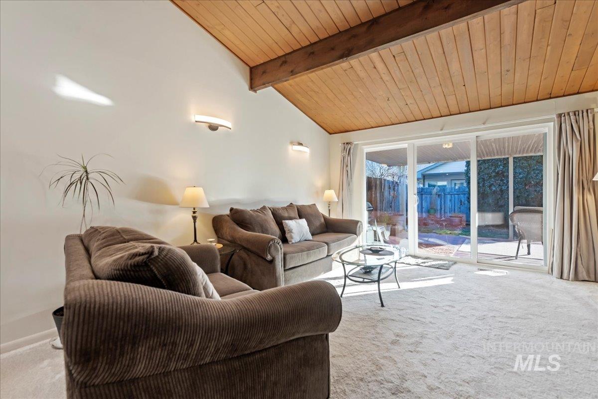 Living area featuring light colored carpet and wood ceiling