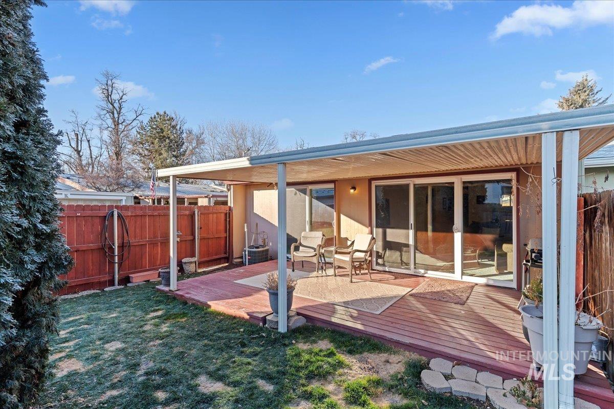 Rear view of property featuring a fenced backyard and a deck