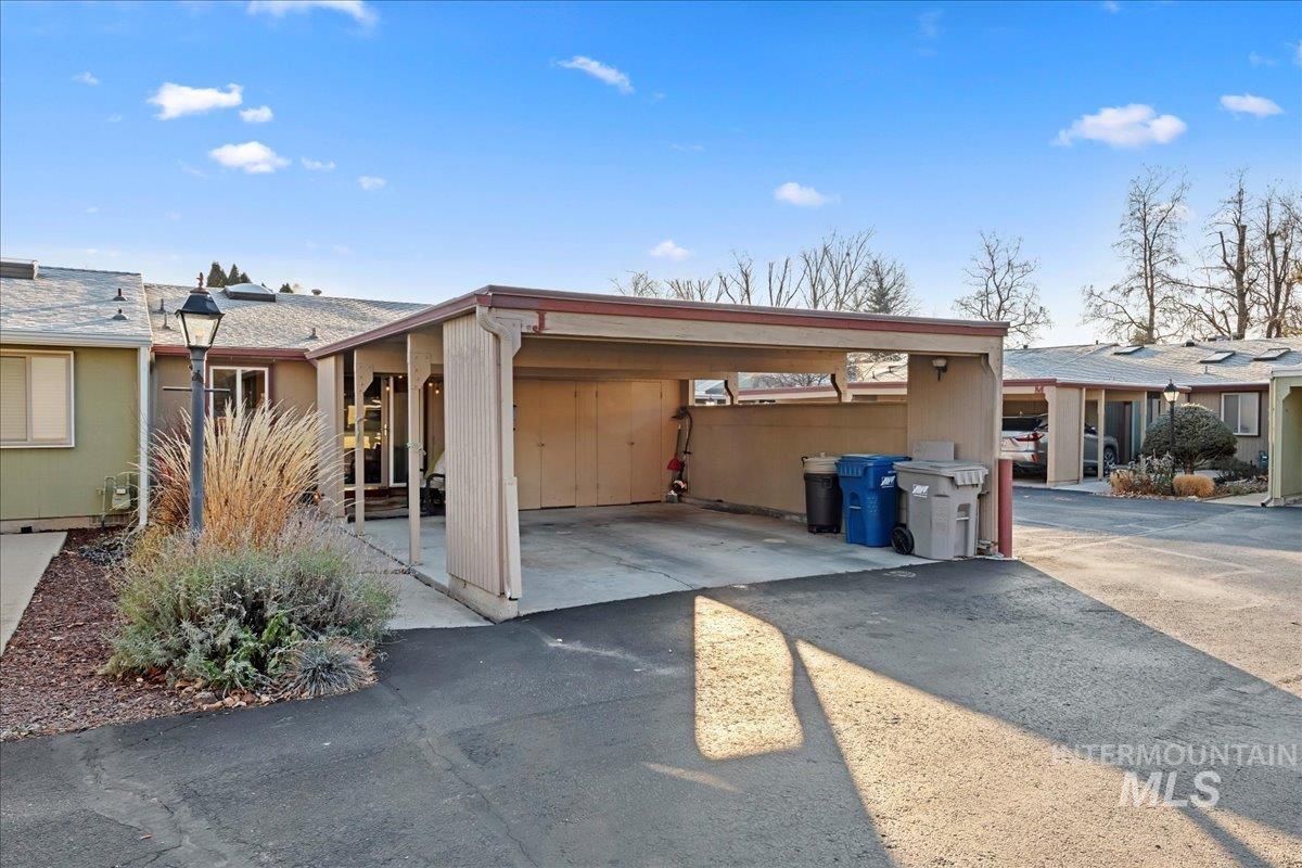 View of side of home with driveway and an attached carport