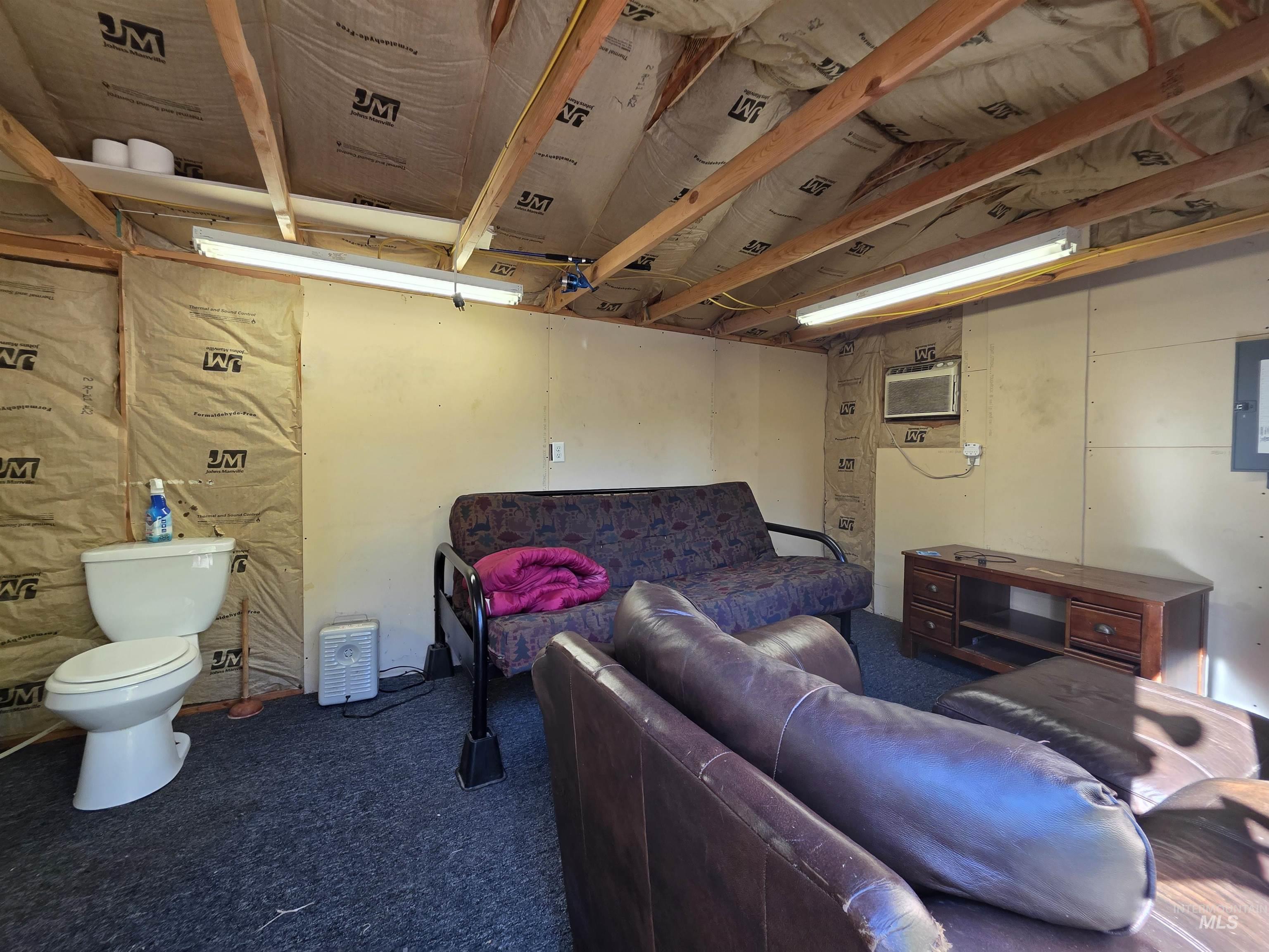 Living room featuring electric panel and dark carpet