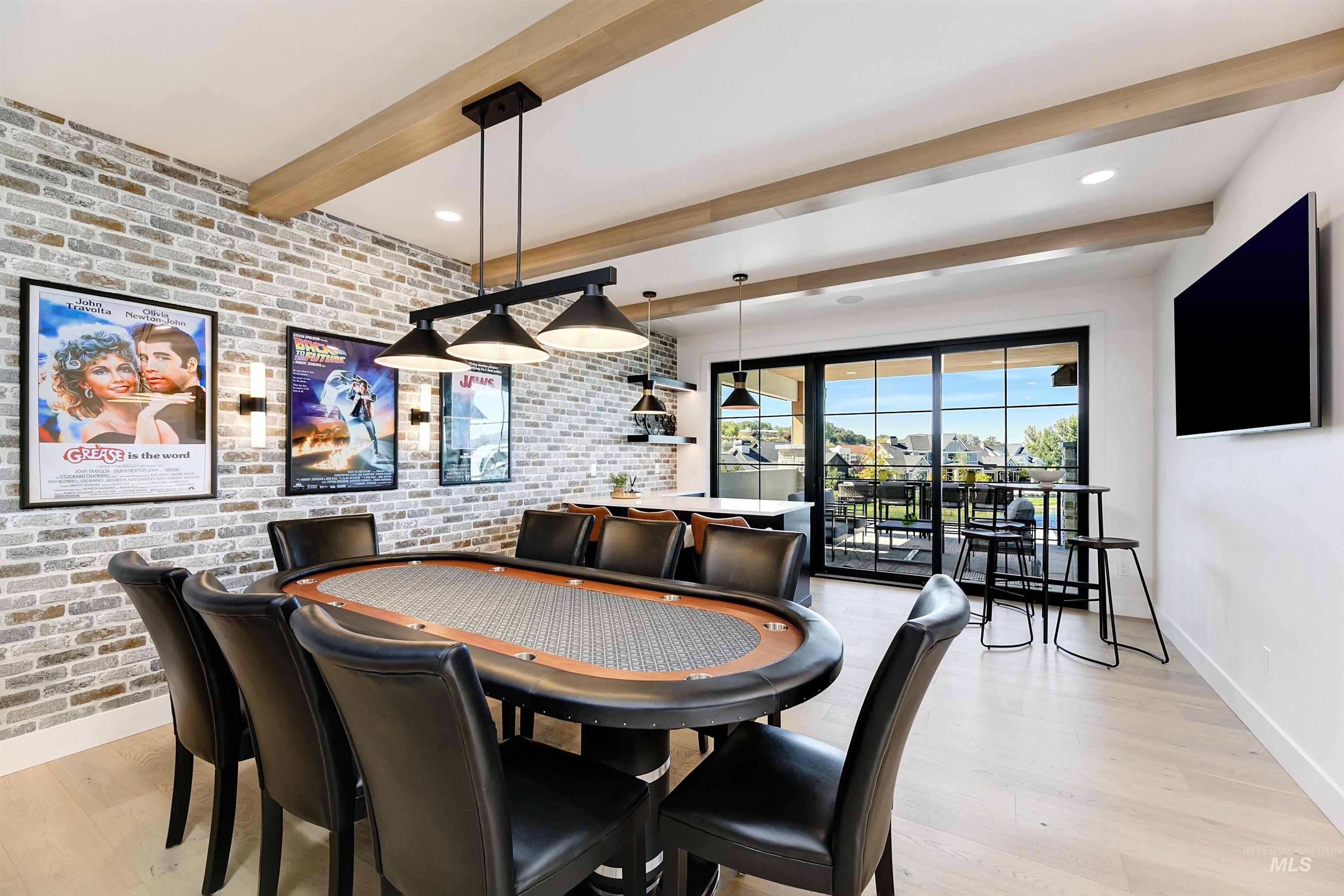 Dining room featuring brick wall, beamed ceiling, and light wood-style floors