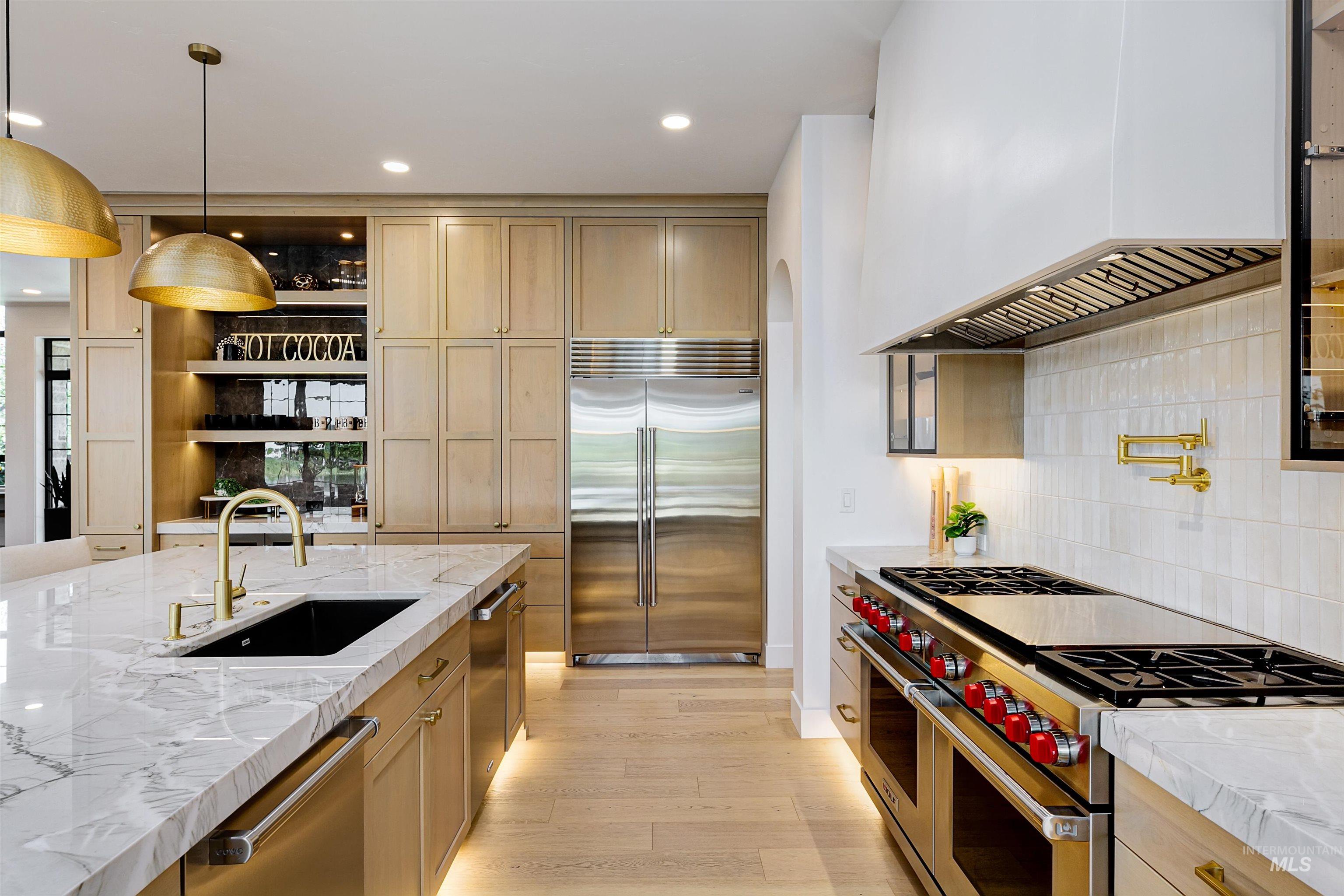 Kitchen featuring high quality appliances, light stone counters, open shelves, premium range hood, and recessed lighting