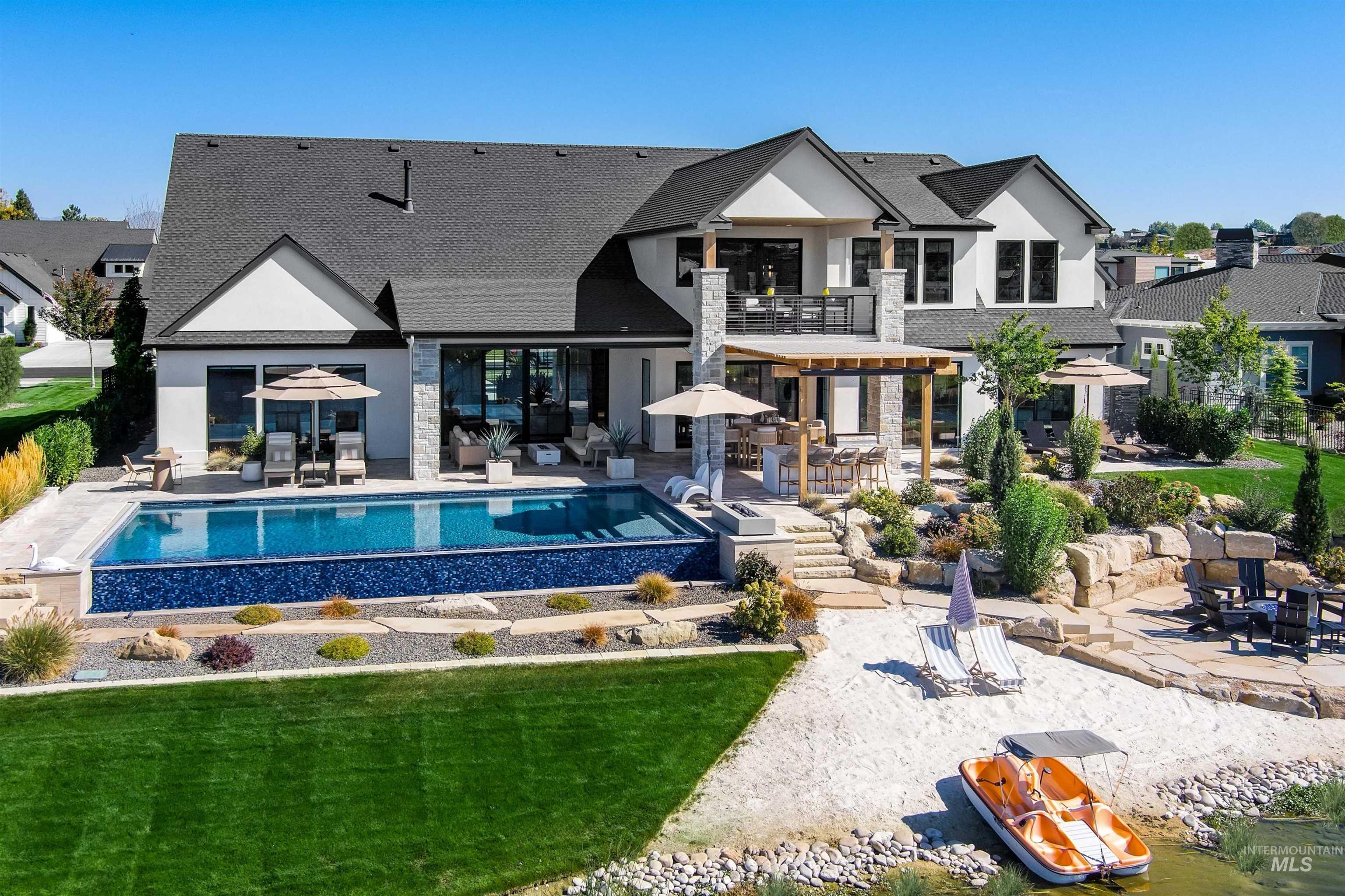 Rear view of property featuring a patio, stucco siding, roof with shingles, and outdoor dining area