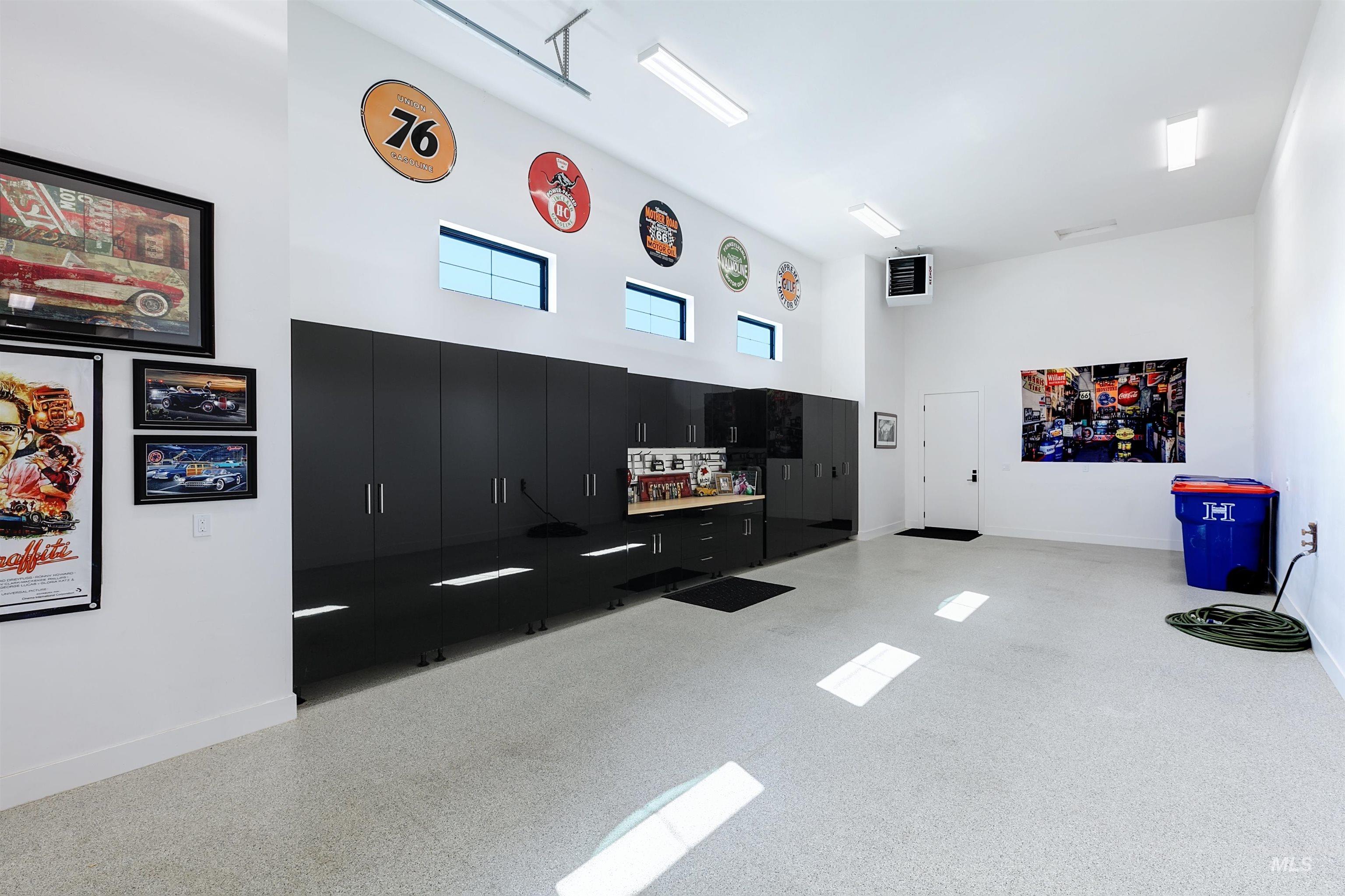 Recreation room with a high ceiling and dark aggregate flooring