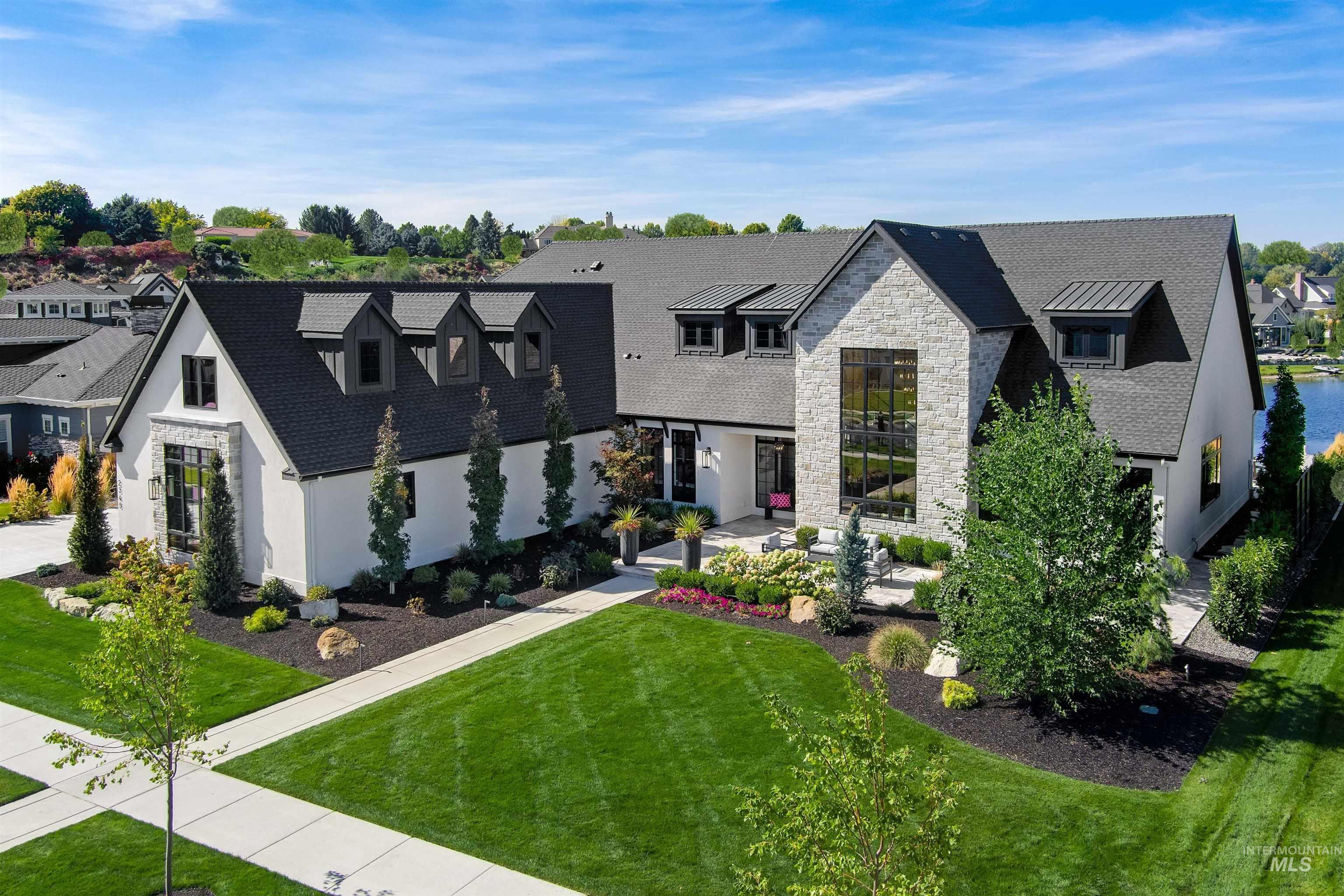 View of front of property featuring stone siding, a front lawn, a residential view, and stucco siding