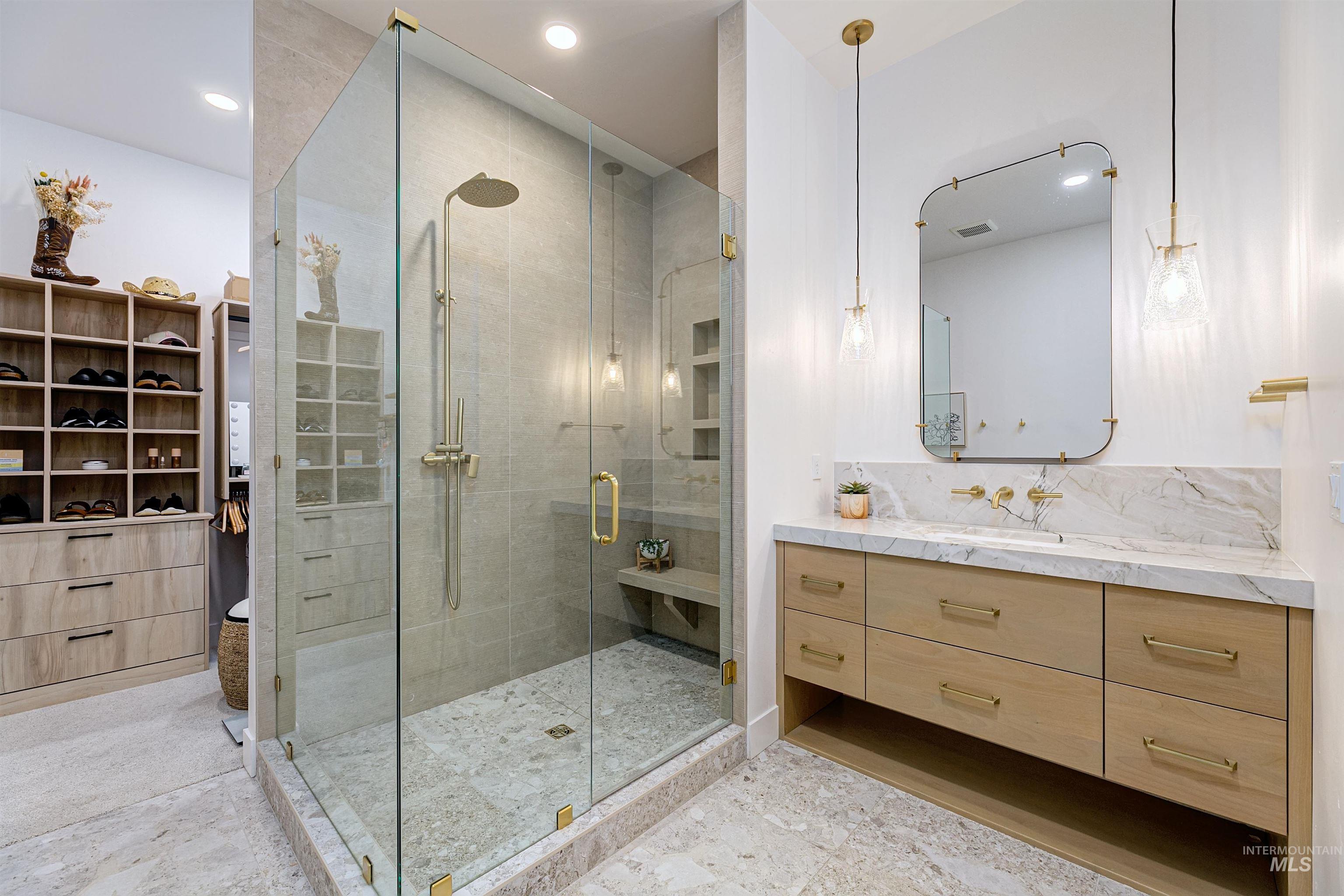 Bathroom with vanity, a shower stall, a walk in closet, recessed lighting, and tasteful backsplash
