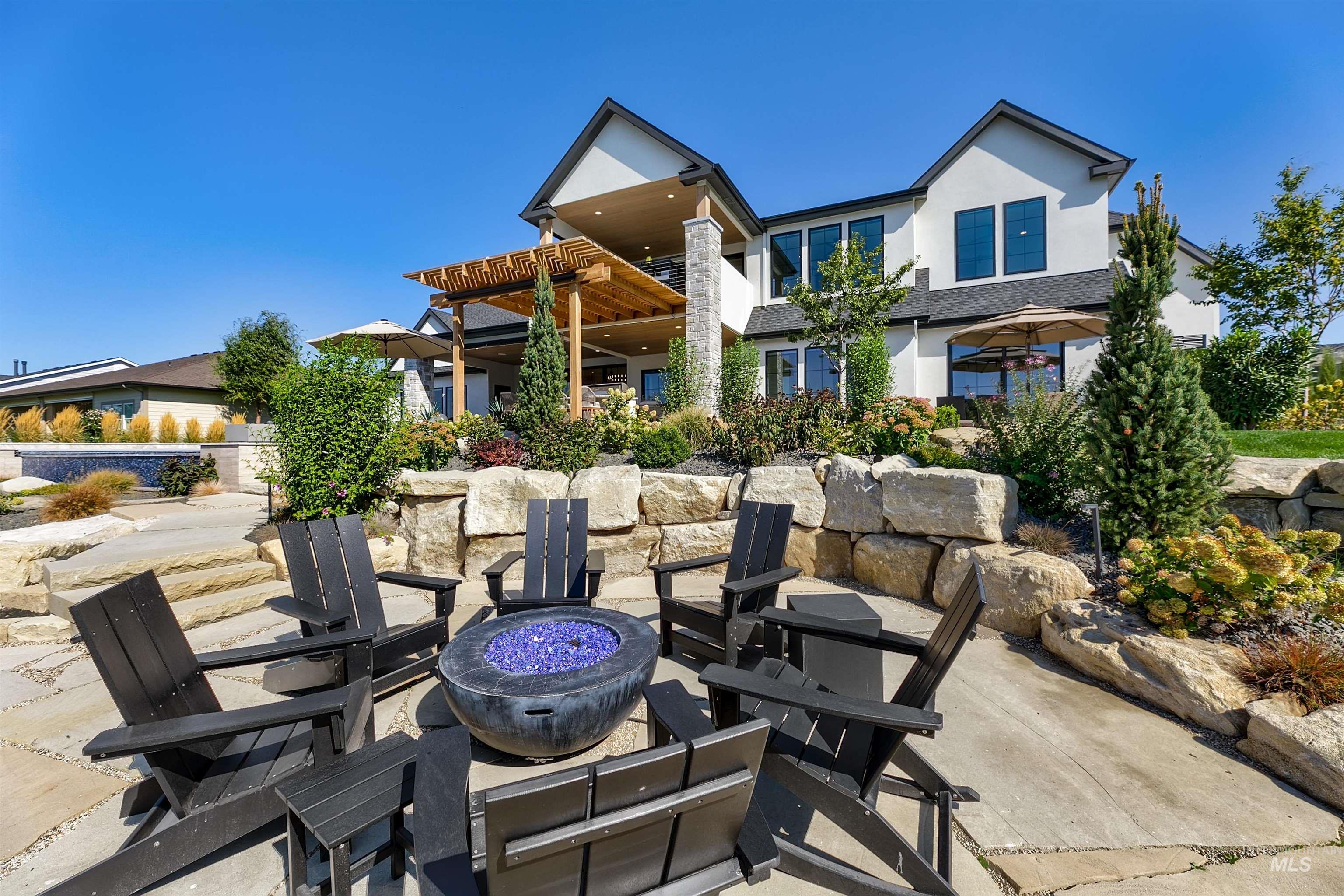 Back of house with a fire pit, stucco siding, a patio area, and a pergola
