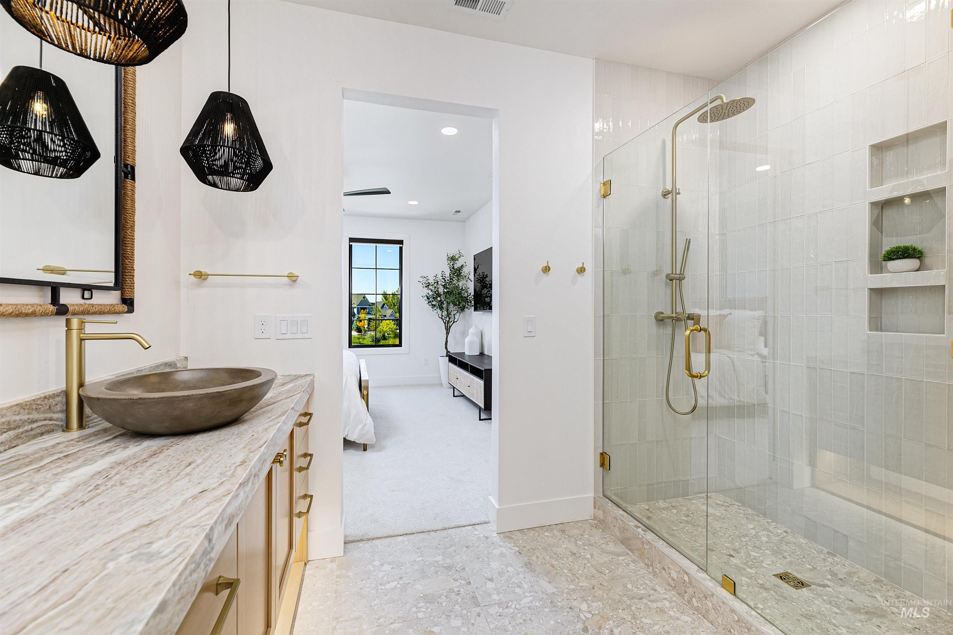 Bathroom with connected bathroom, a stall shower, vanity, and recessed lighting