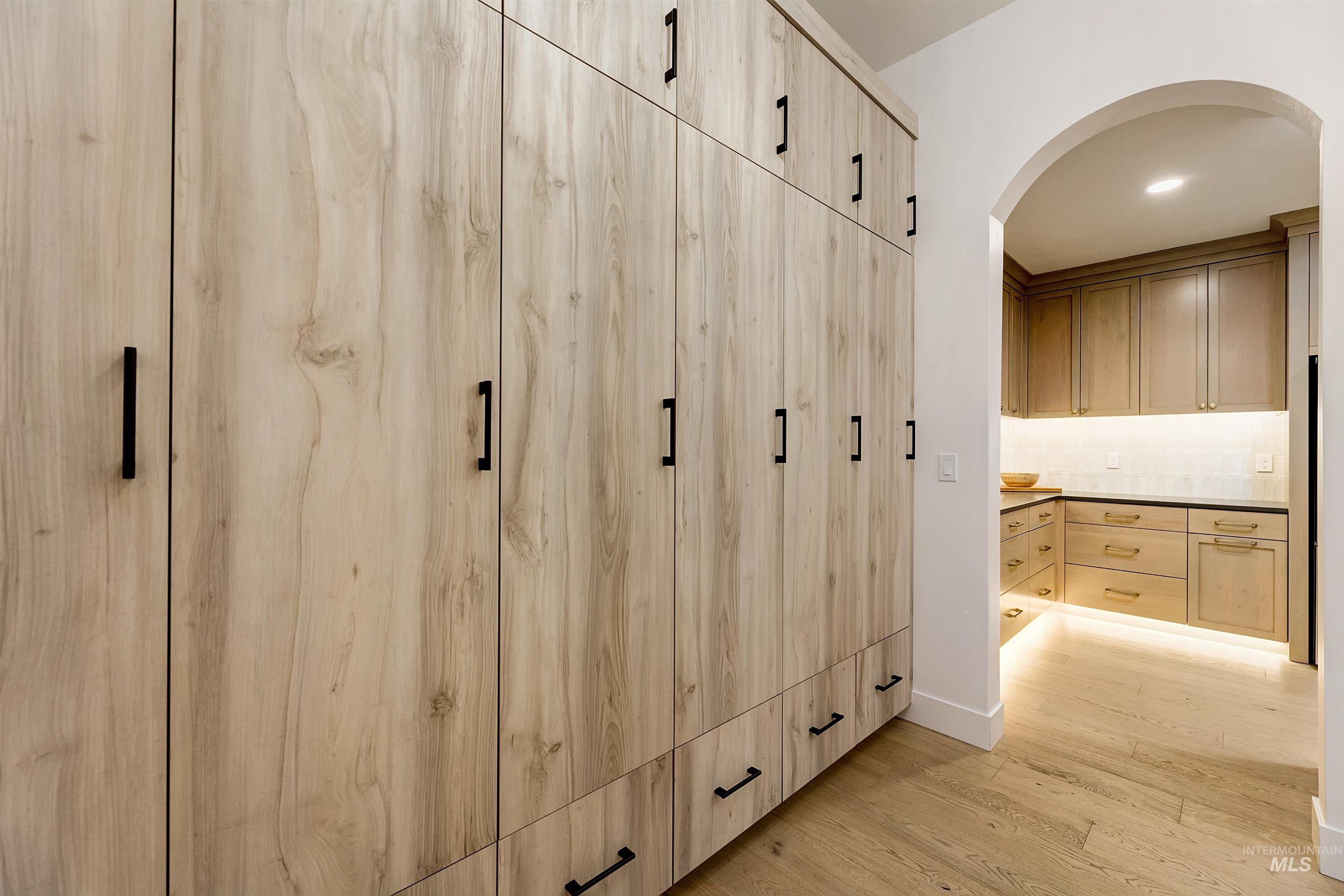 Mudroom with light wood-type flooring, recessed lighting, and arched walkways