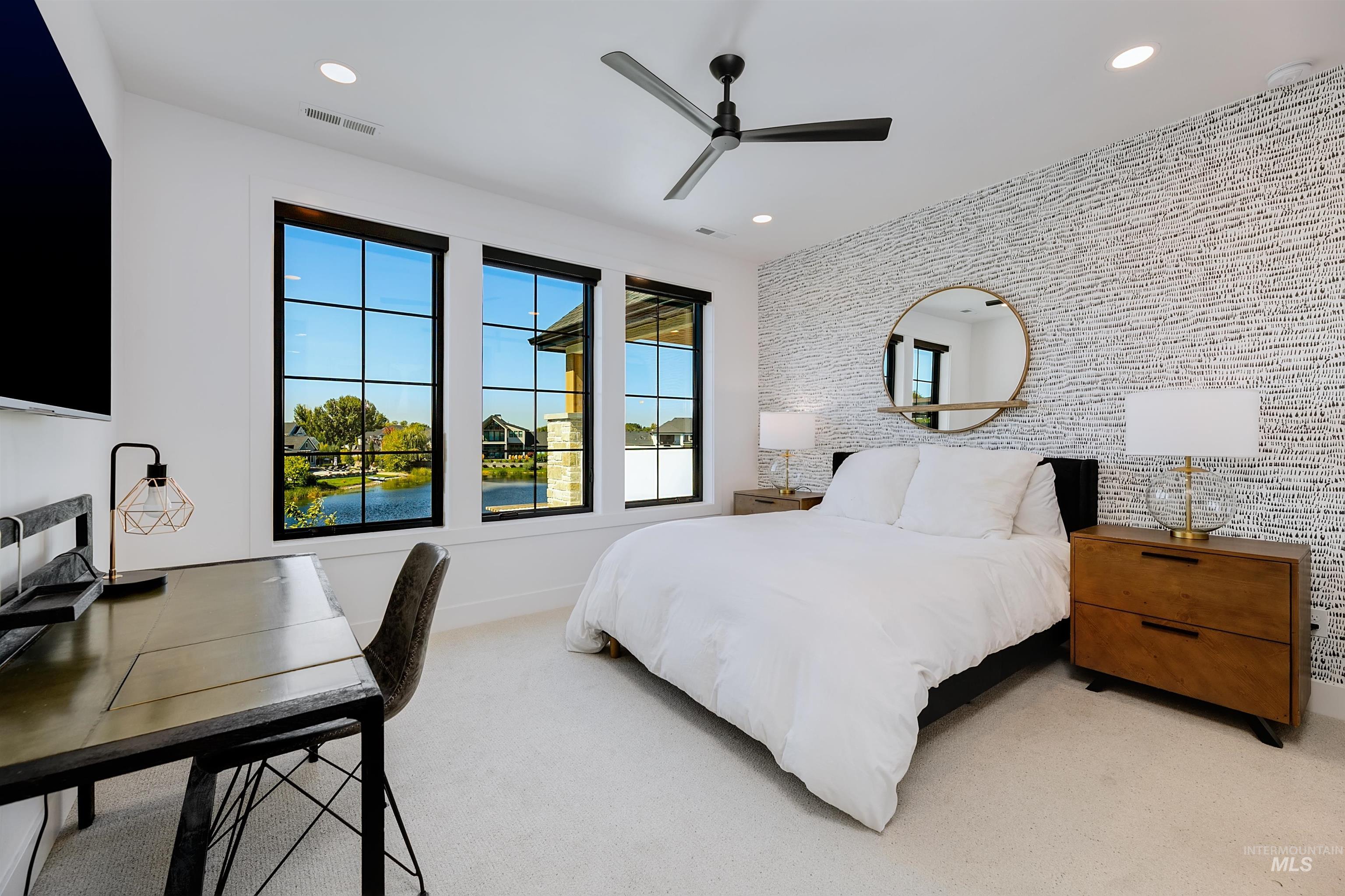Bedroom with light colored carpet, ceiling fan, recessed lighting, an accent wall, and a desk