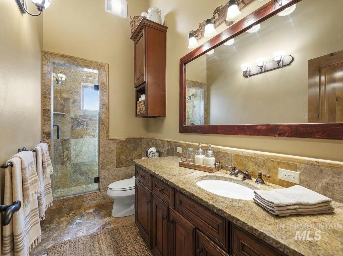 Second Floor Full bath with vanity, a shower stall, and tile walls