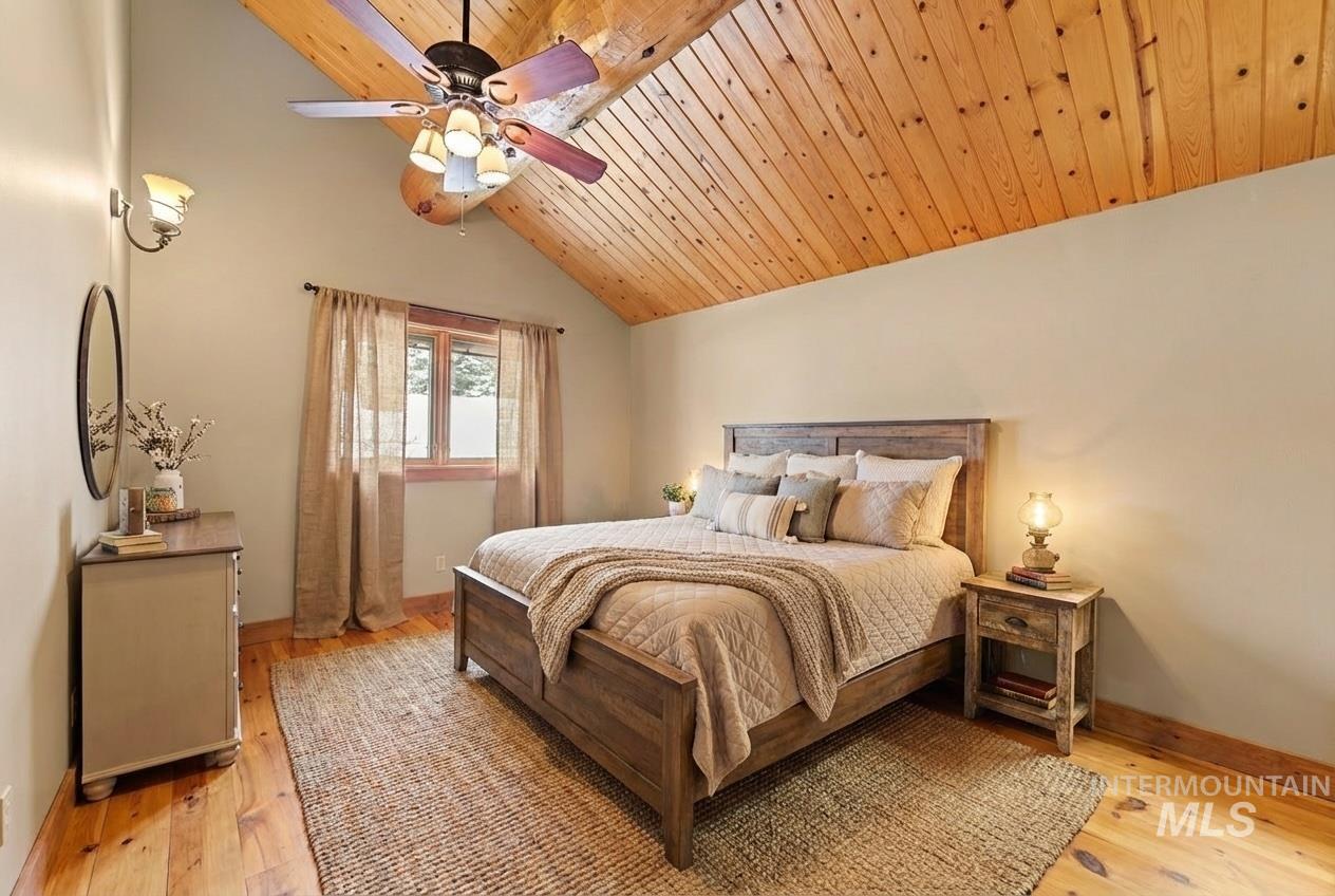 Bedroom featuring light wood finished floors, wood ceiling, ceiling fan, and lofted ceiling