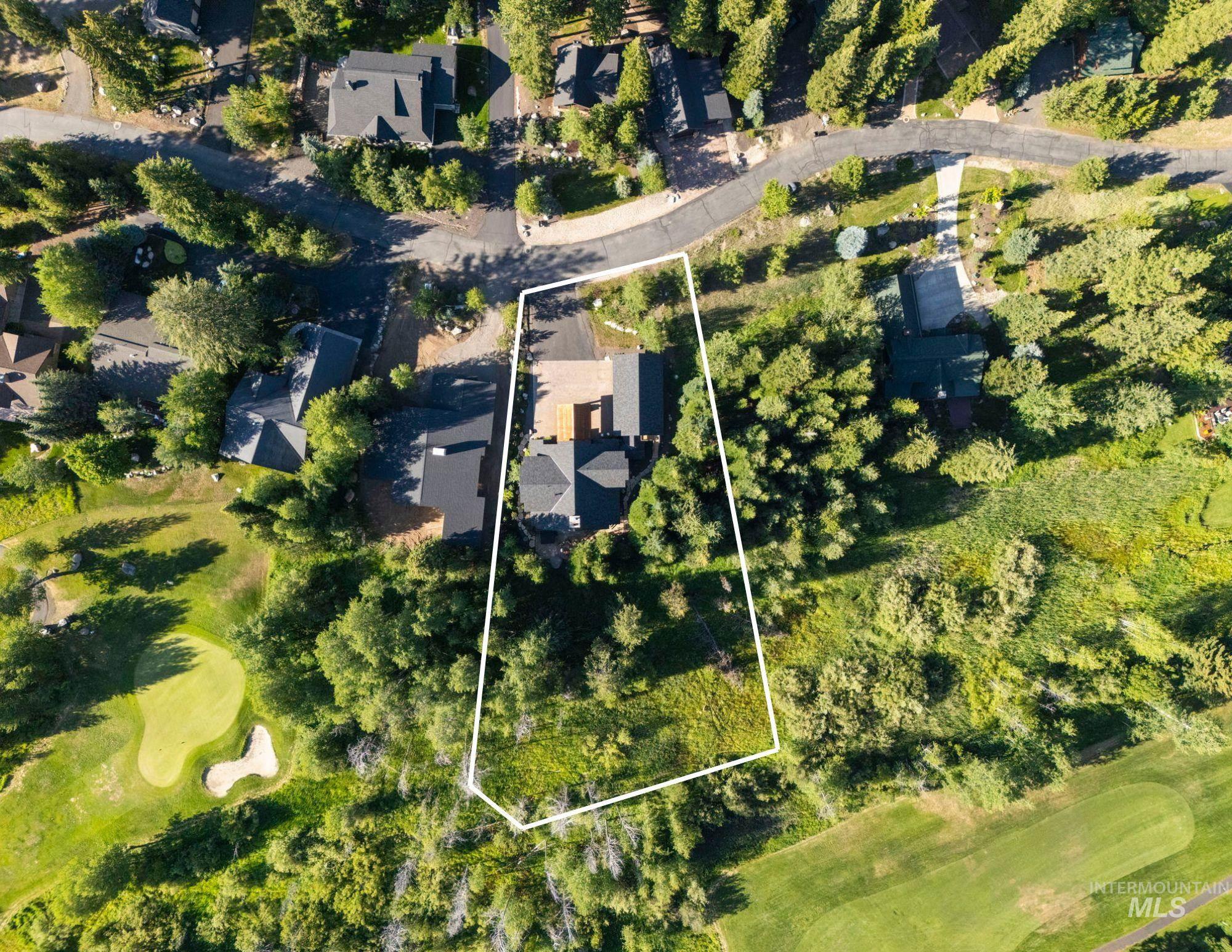 Aerial perspective of suburban area featuring property boundaries highlighted and a golf course