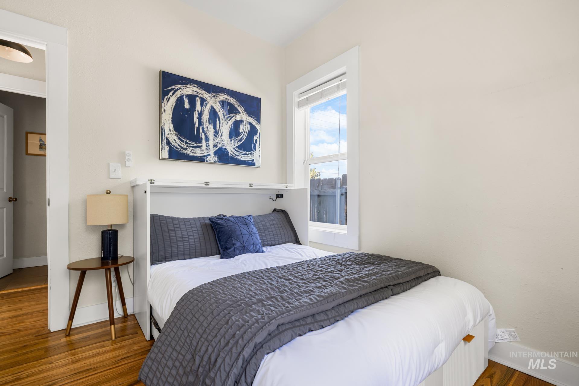 Room featuring light-toned walls and wood-finish flooring