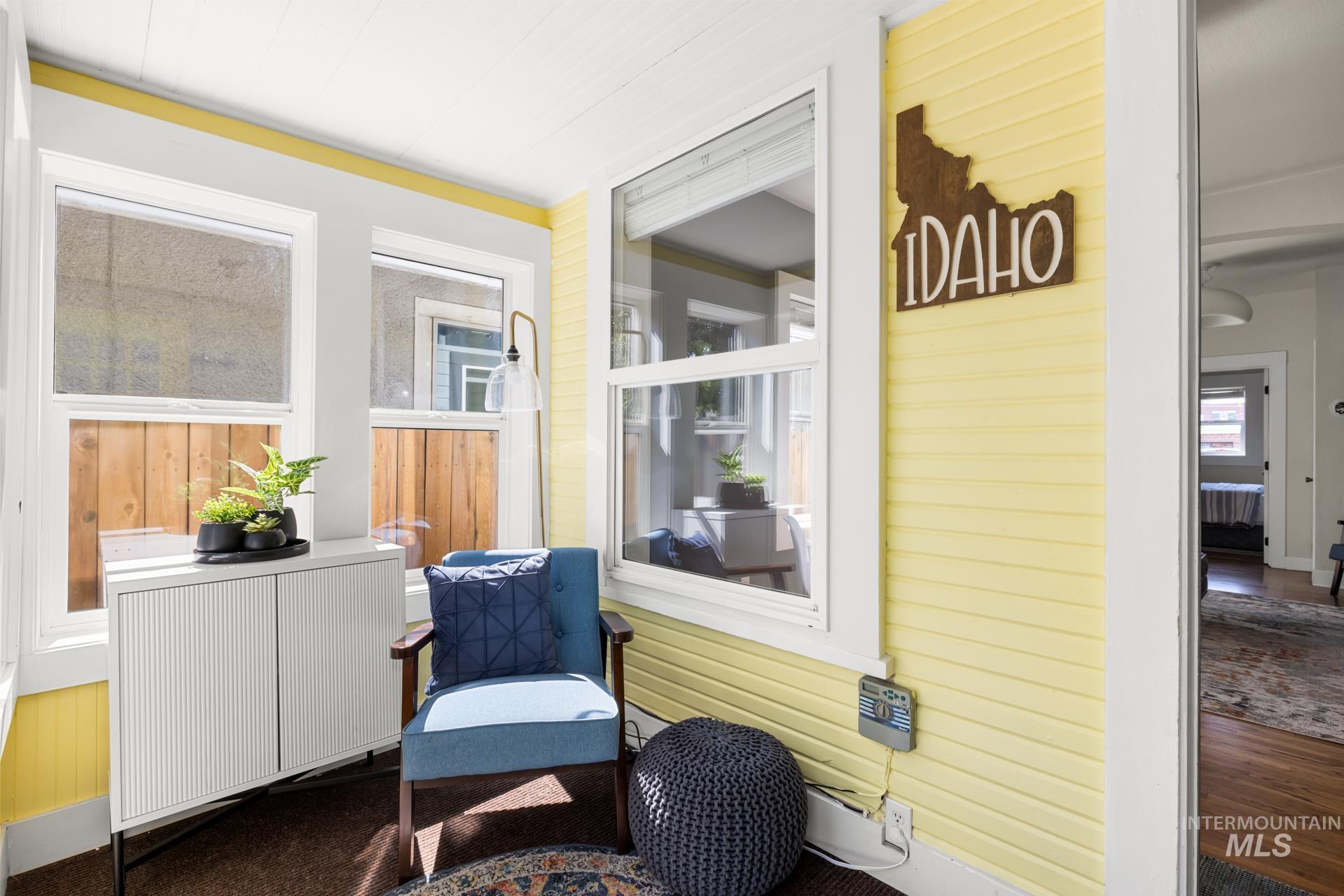 Sunlit enclosed porch featuring yellow horizontal paneling and white trim