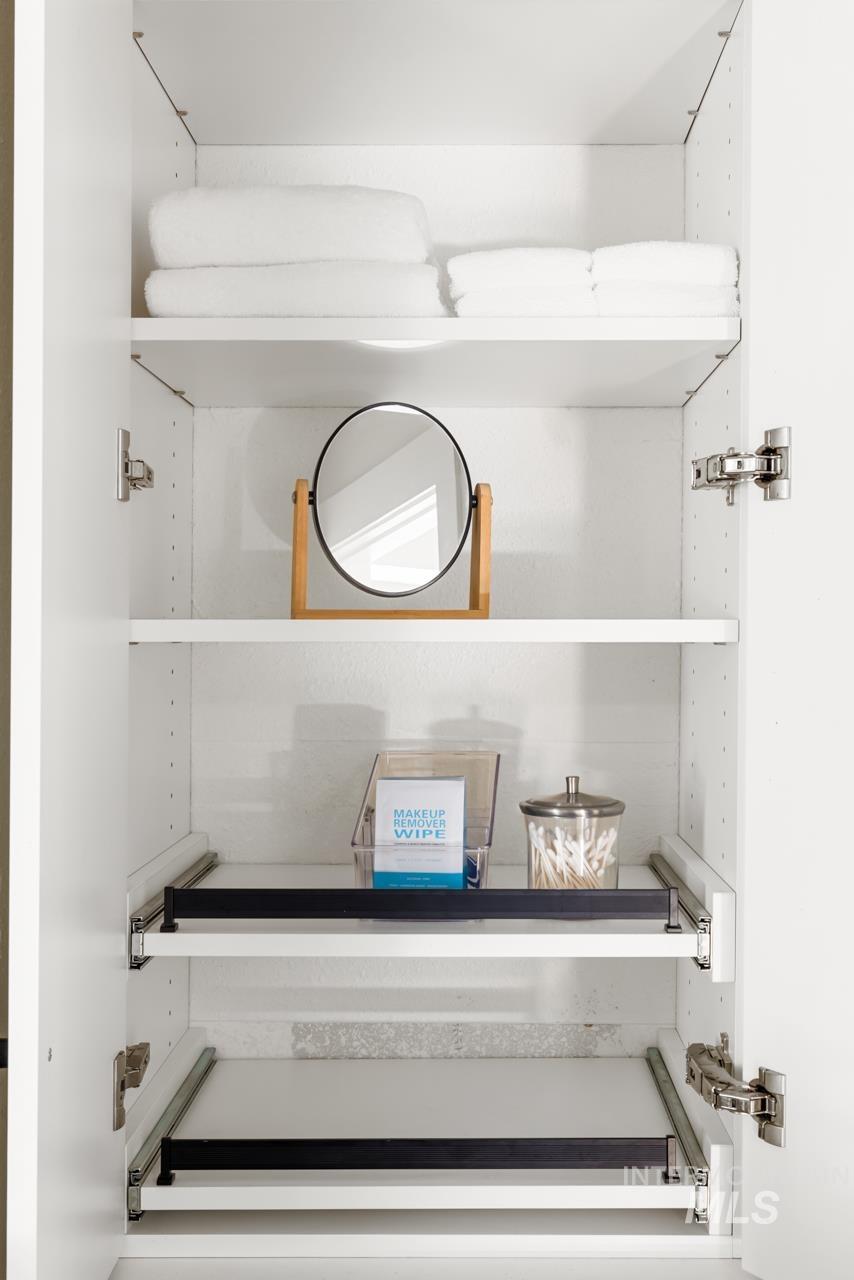 White built-in cabinetry featuring adjustable shelving, soft-close hinges, and pull-out drawers with black hardware