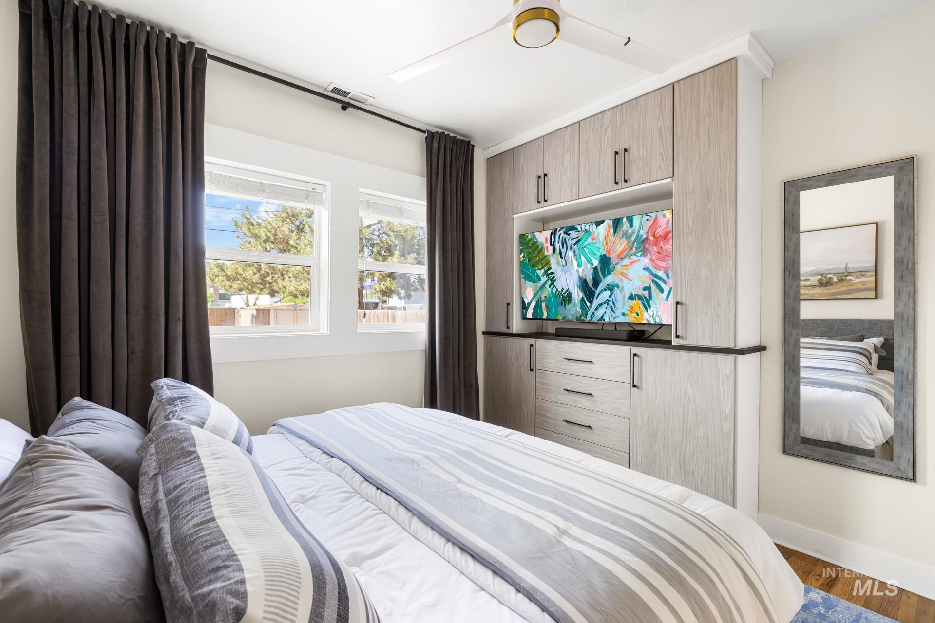 Custom built-in cabinetry with wood-finish doors and drawers, featuring a dedicated media niche and dark countertop
