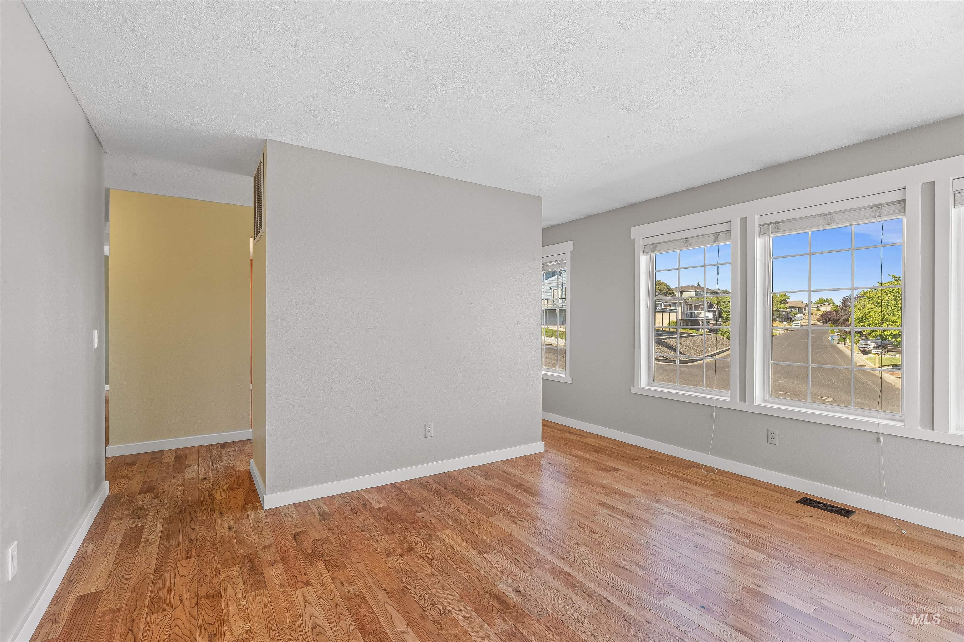 Spare room with light wood-style flooring and a textured ceiling