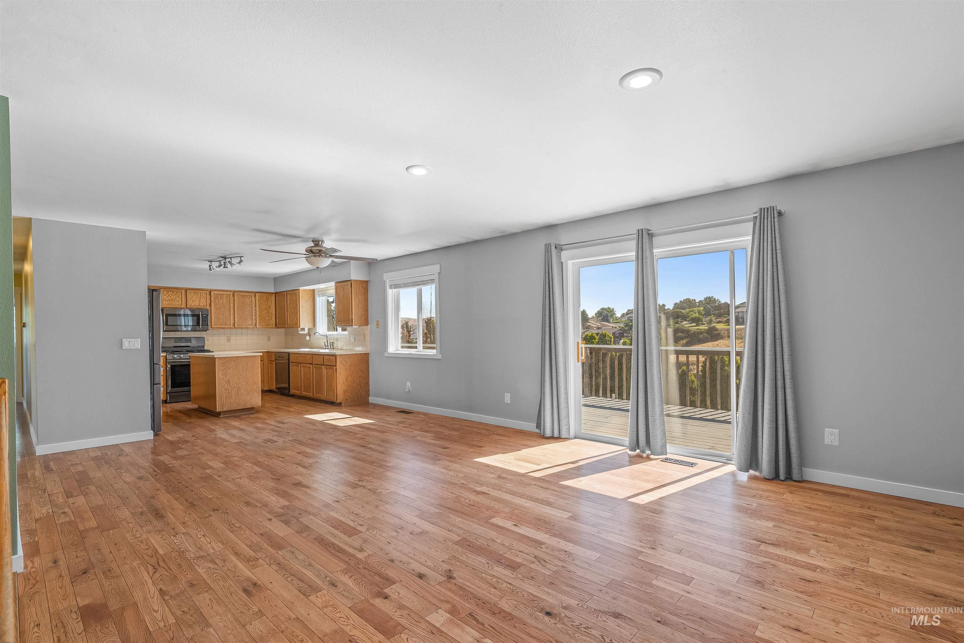 Unfurnished living room with light wood finished floors, ceiling fan, and recessed lighting