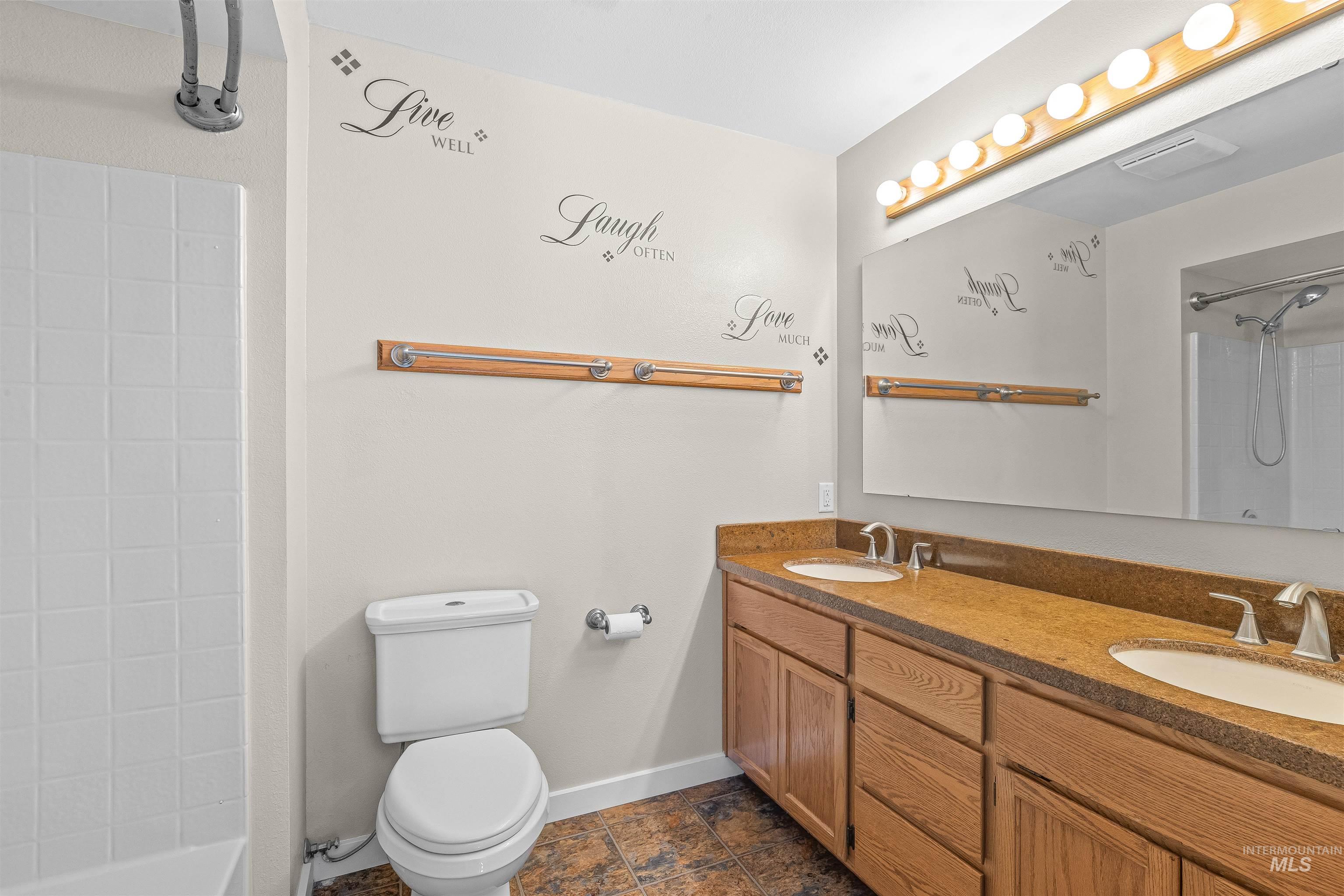 Full bath with double vanity and toilet