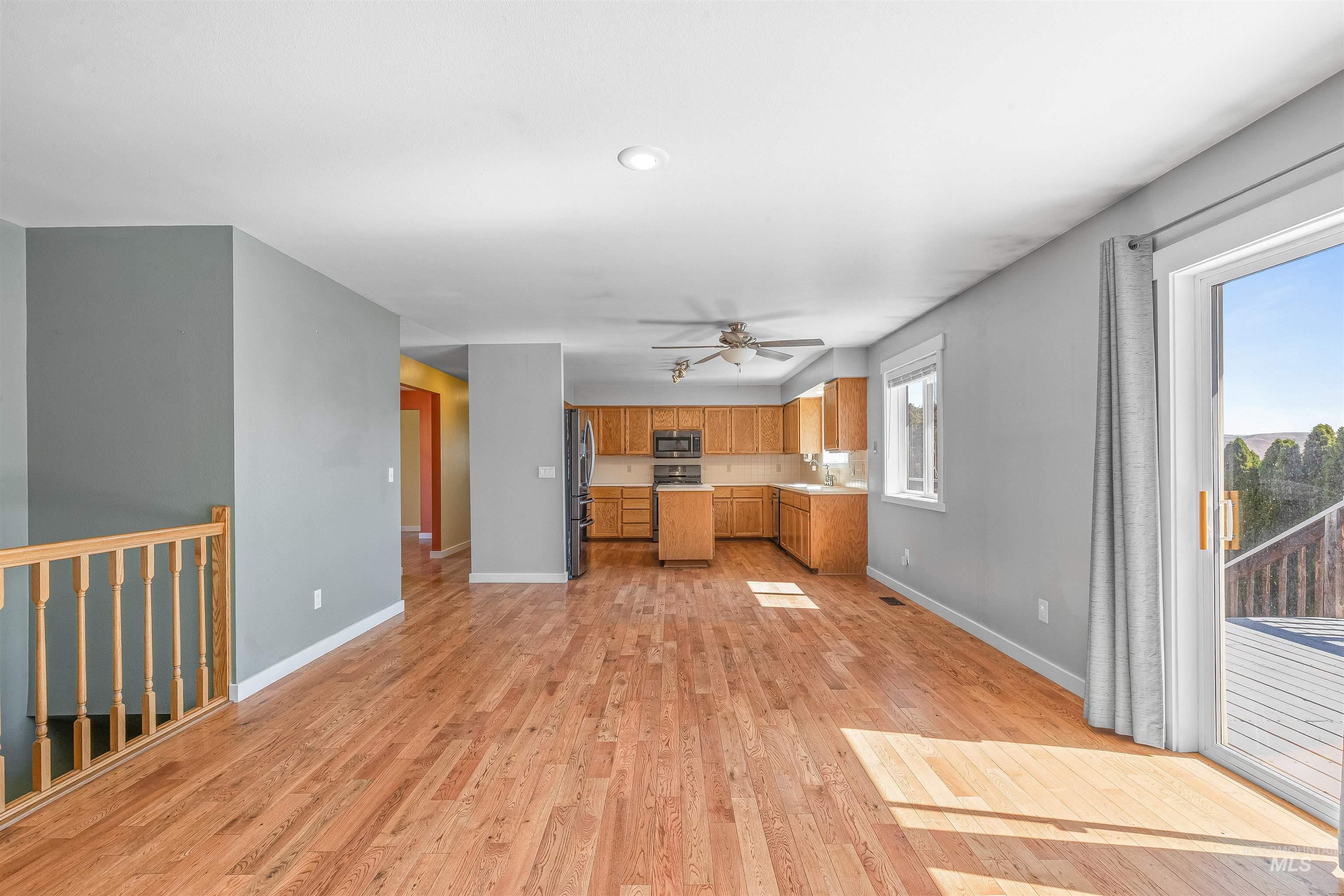 Unfurnished living room featuring light wood finished floors and ceiling fan