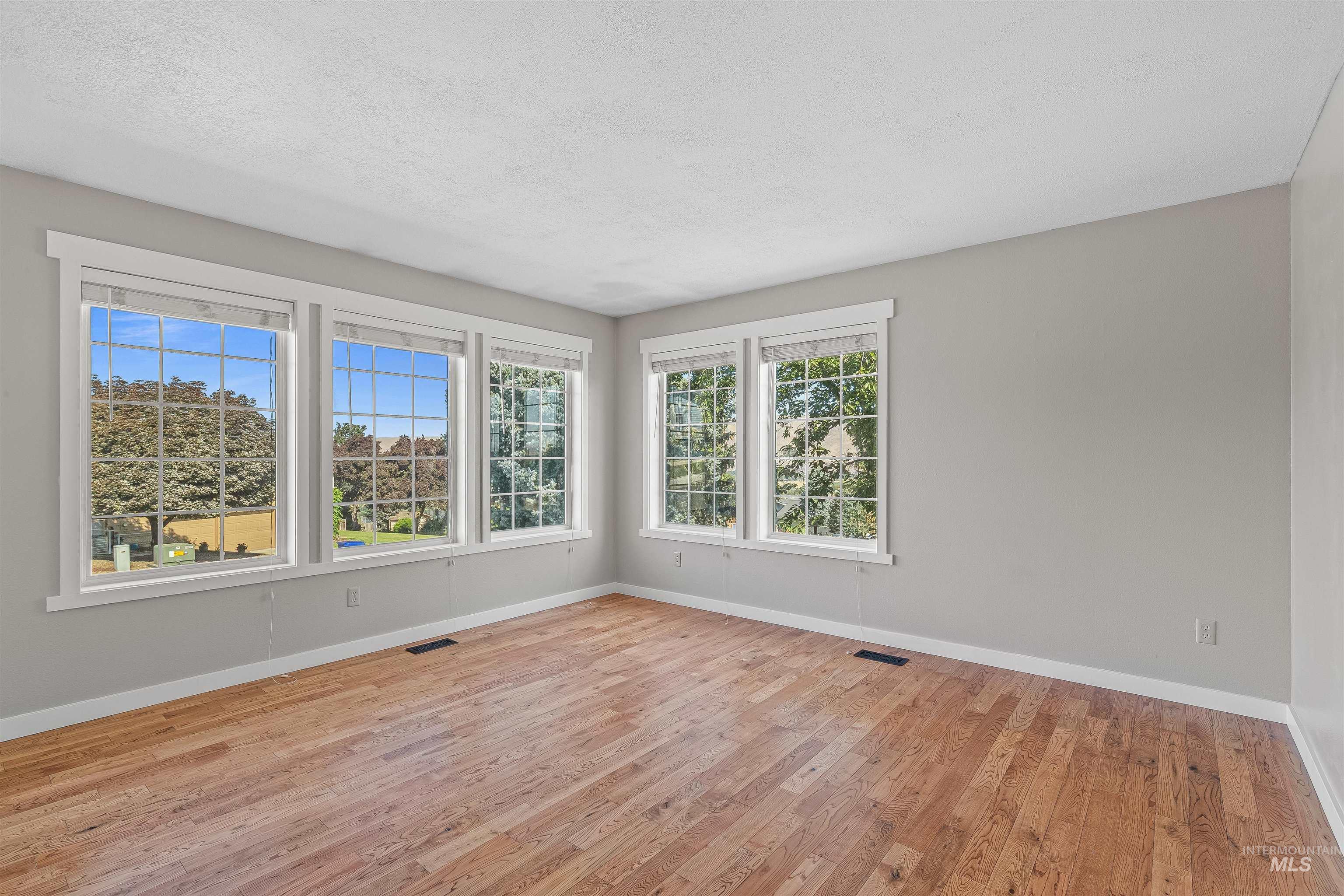 Empty room featuring wood finished floors and a textured ceiling