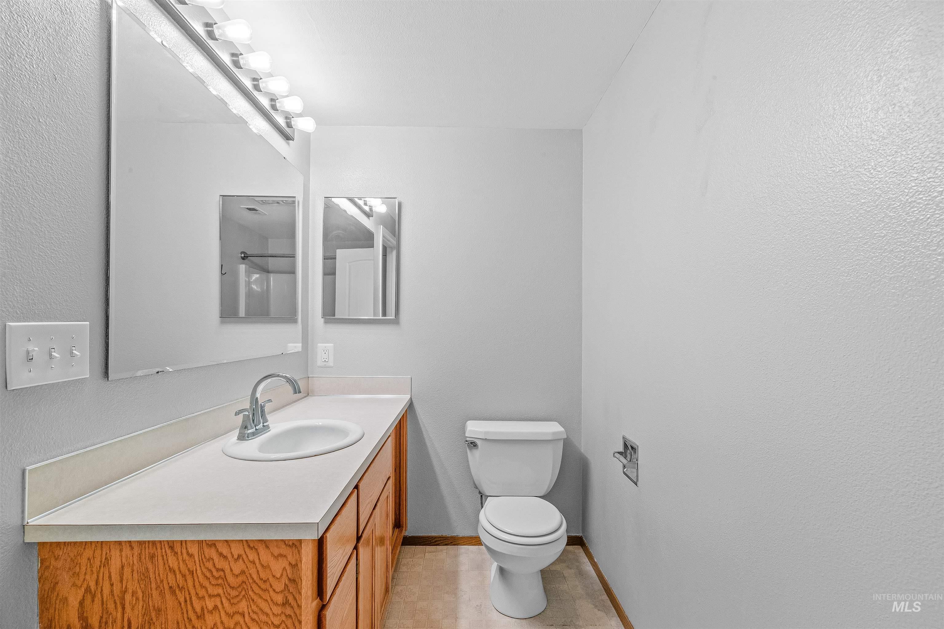 Half bathroom with vanity and tile patterned flooring