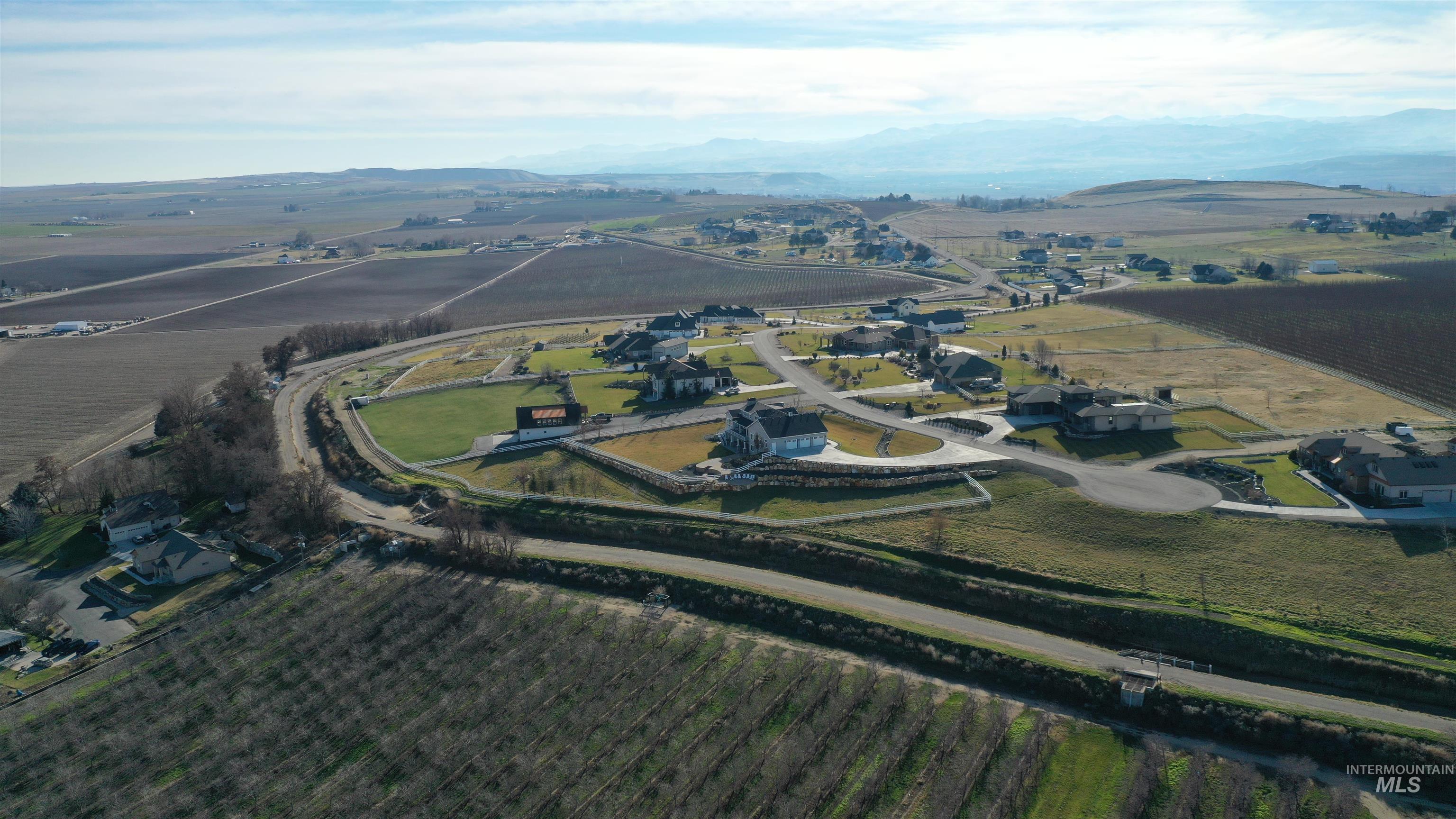Aerial overview of property's location featuring abundant farmland, rural landscape, and a mountainous background