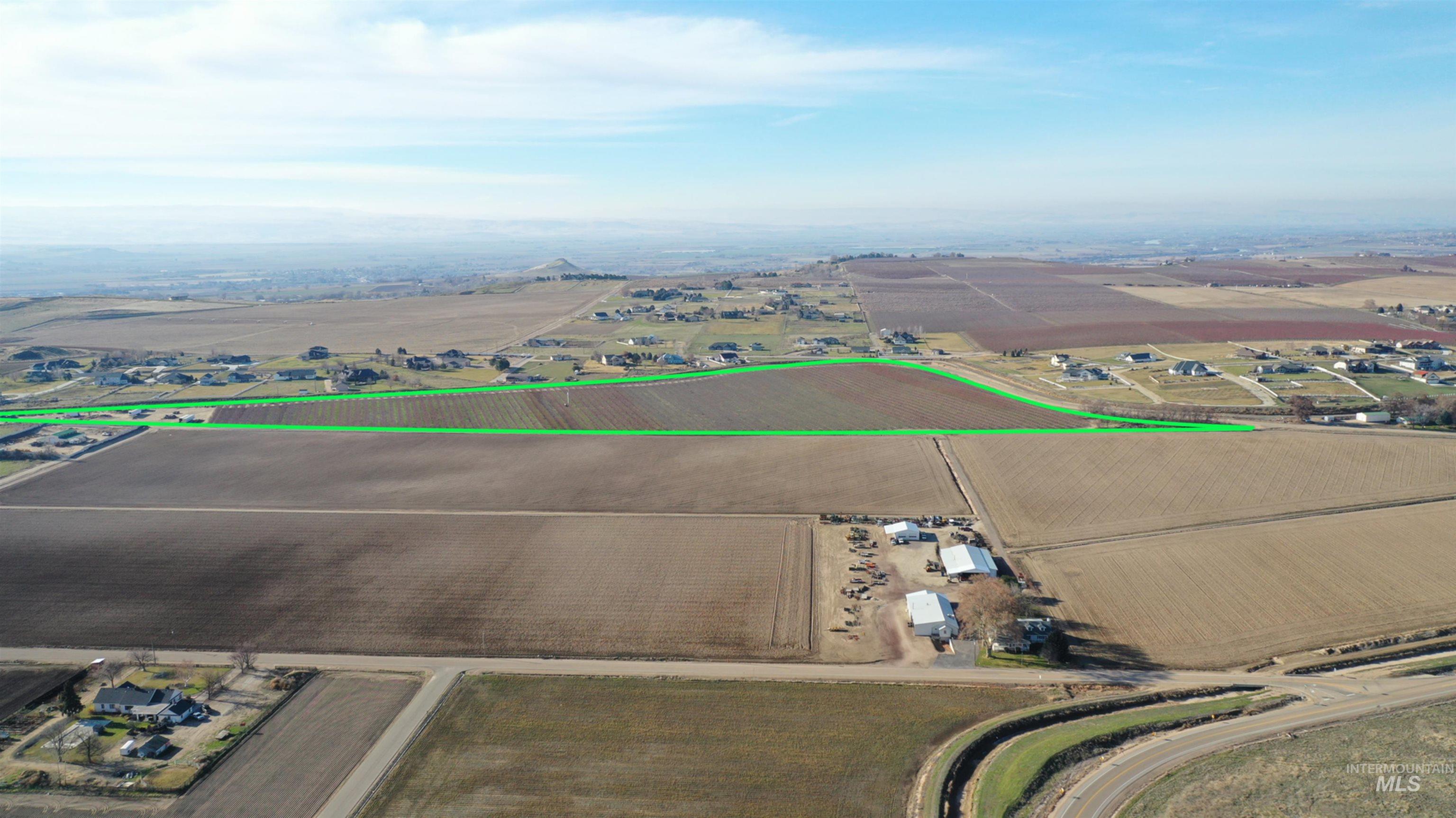 Aerial view of sparsely populated area with rows of crops and property parcel outlined