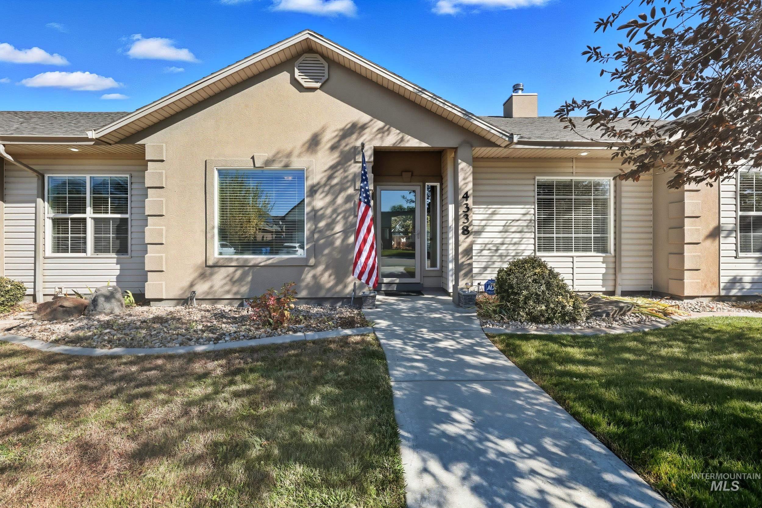 View of front of home with roof with shingles, a front yard, a chimney, and stucco siding