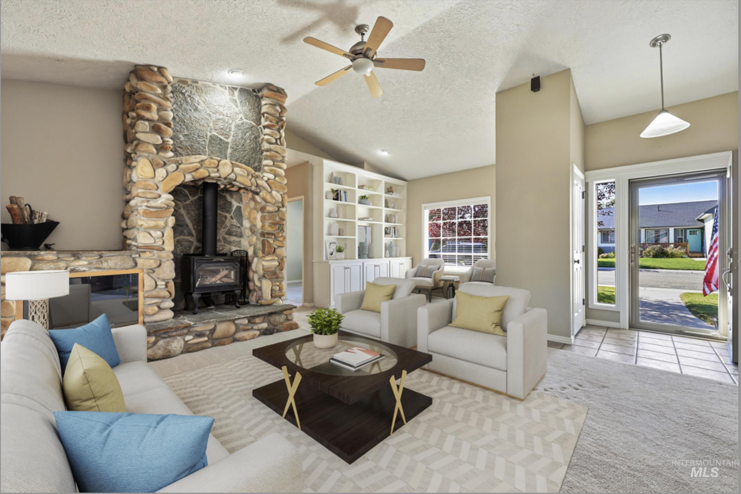 Living area featuring a wood stove, a textured ceiling, vaulted ceiling, ceiling fan, and carpet