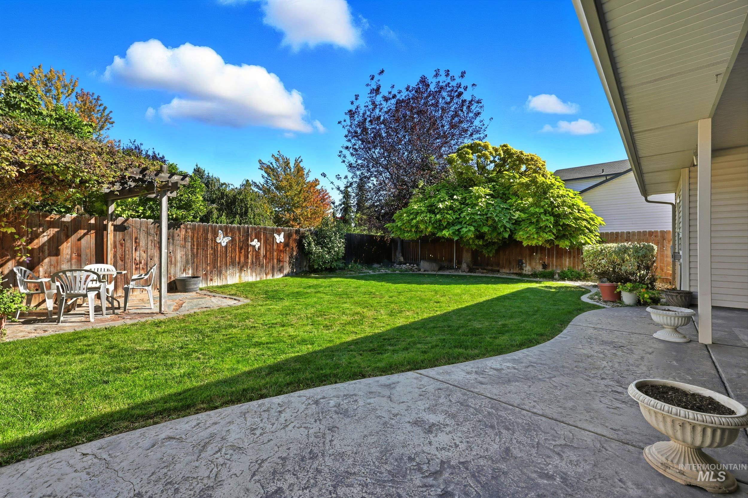 Fenced backyard featuring a patio and a pergola