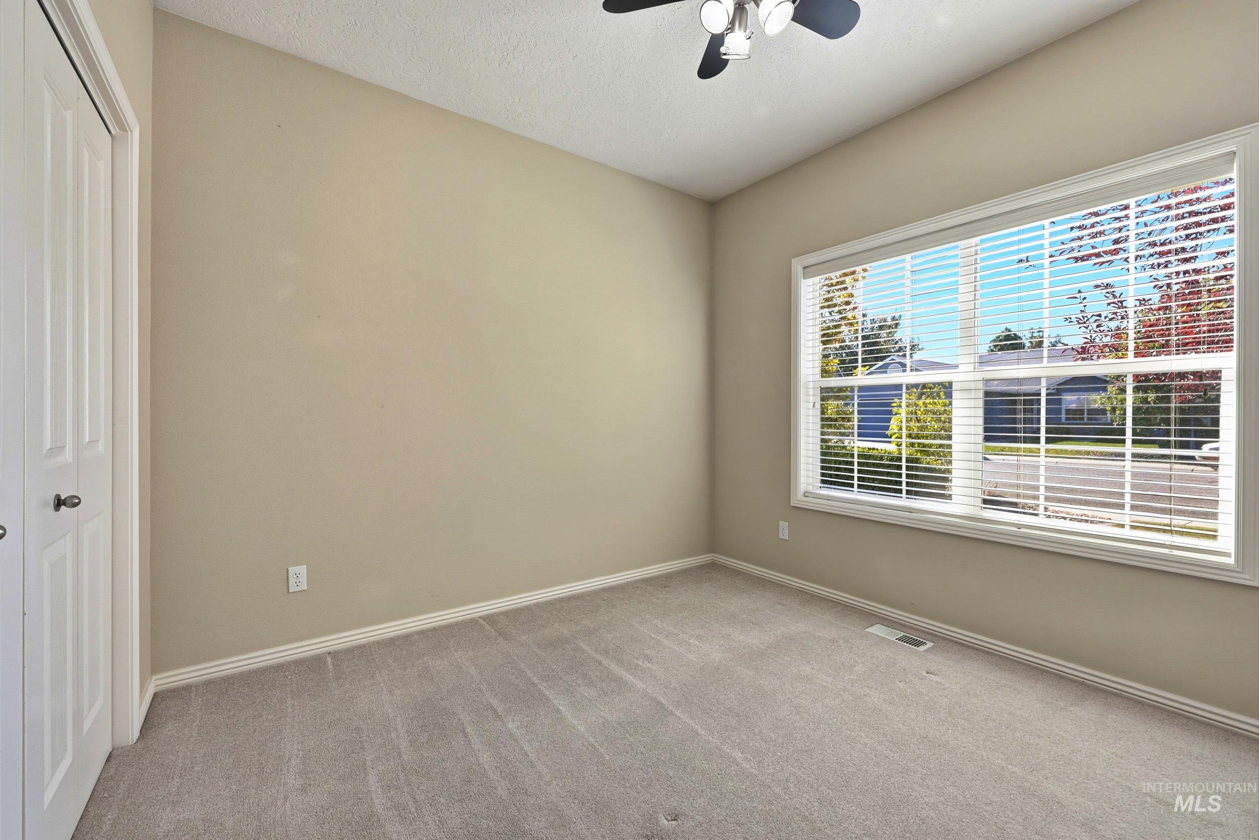 Unfurnished bedroom featuring a closet, carpet, a ceiling fan, and a textured ceiling