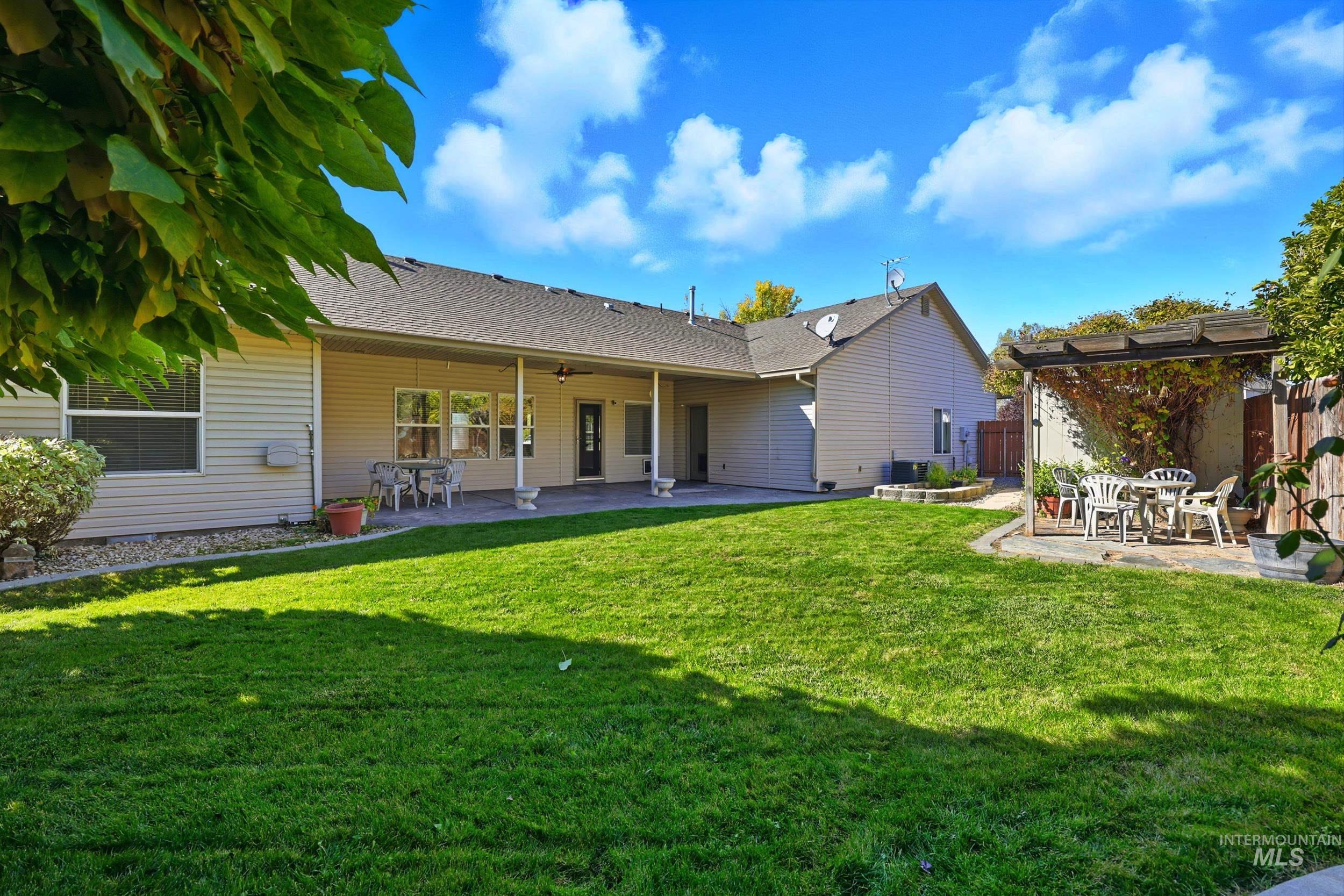Back of property with a patio area, roof with shingles, and ceiling fan