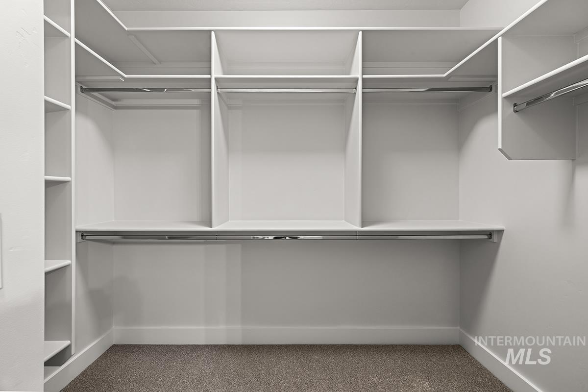 Custom closet system featuring multiple hanging rods, integrated shelving, and white cabinetry