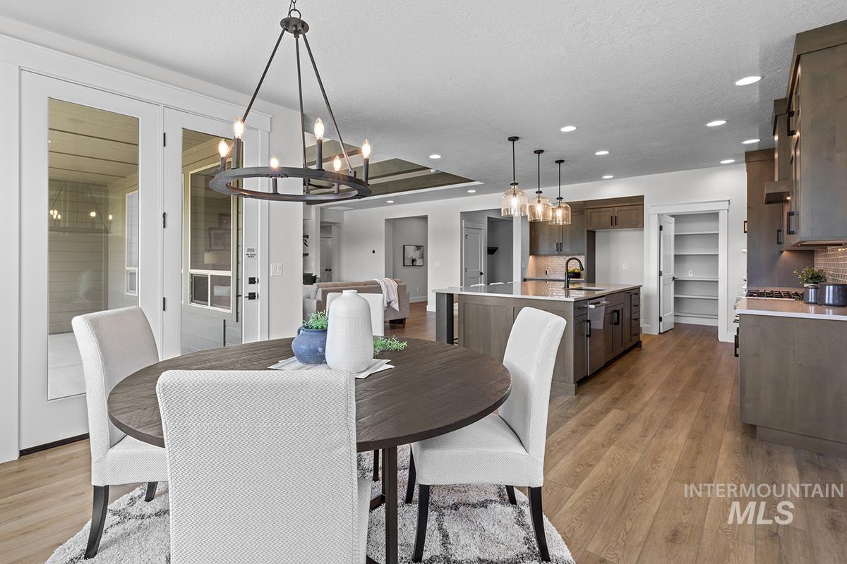 Open-concept dining and kitchen area featuring wood-finish flooring