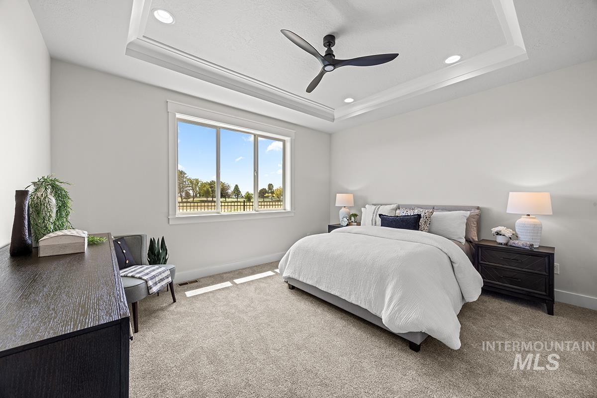 Bedroom featuring a tray ceiling with recessed lighting and a ceiling fan