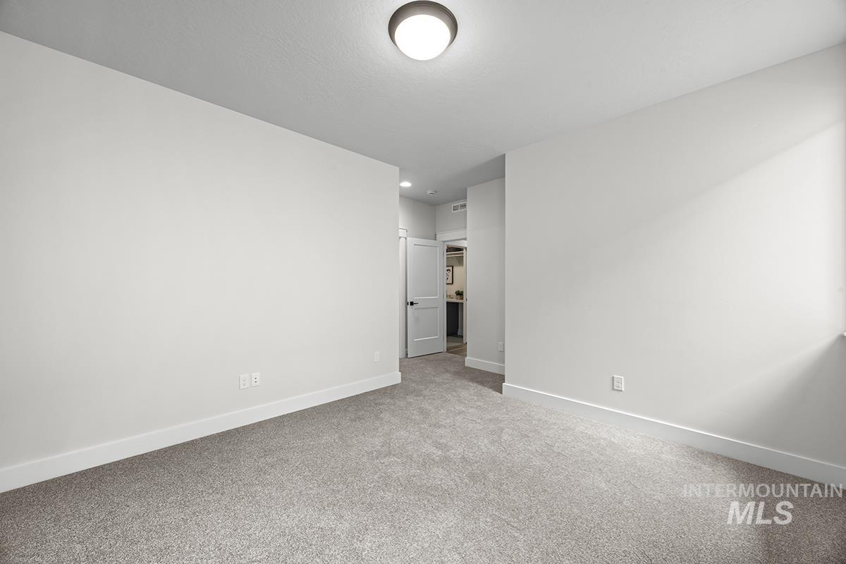 Spacious room featuring neutral carpeting and light-toned walls