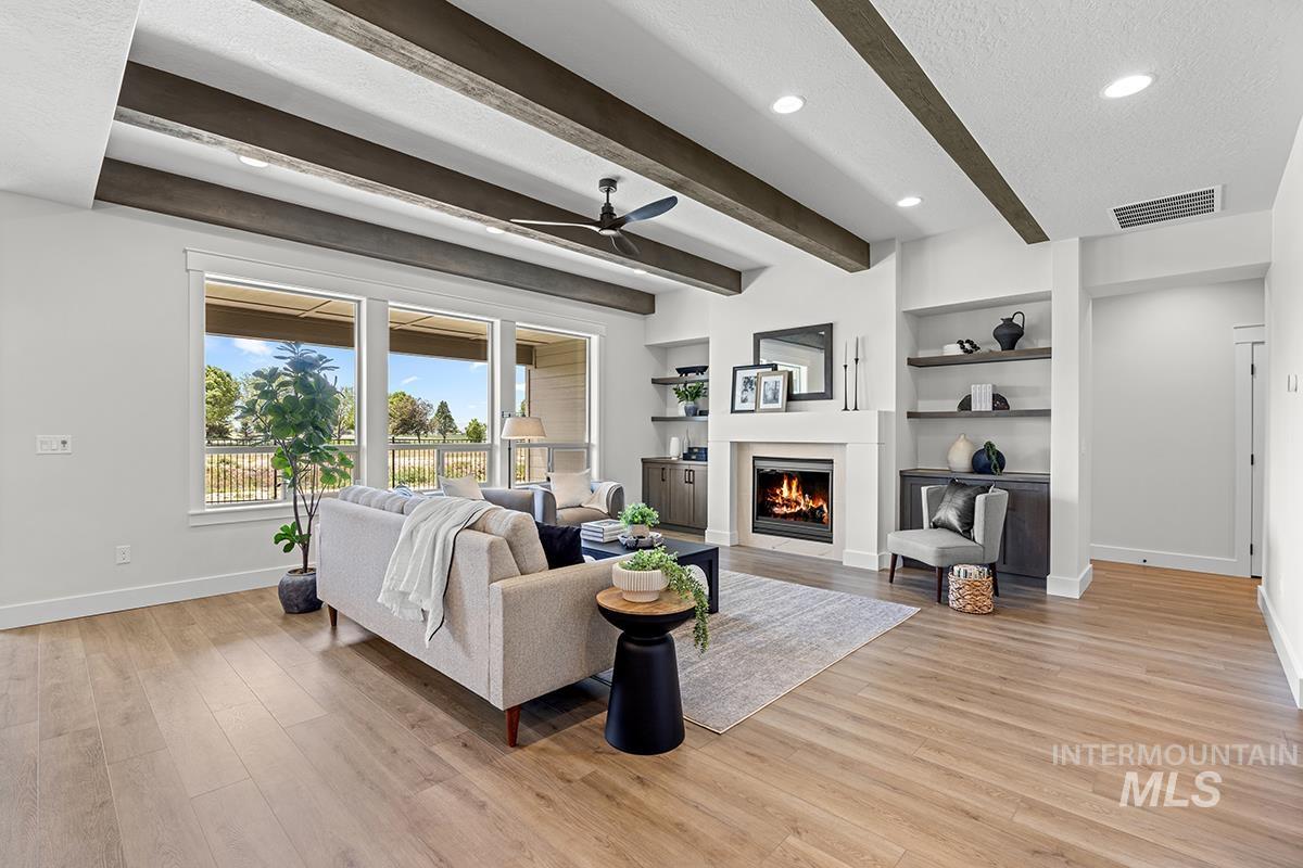 Living area featuring wood-finish flooring, exposed ceiling beams, recessed lighting, and a contemporary ceiling fan