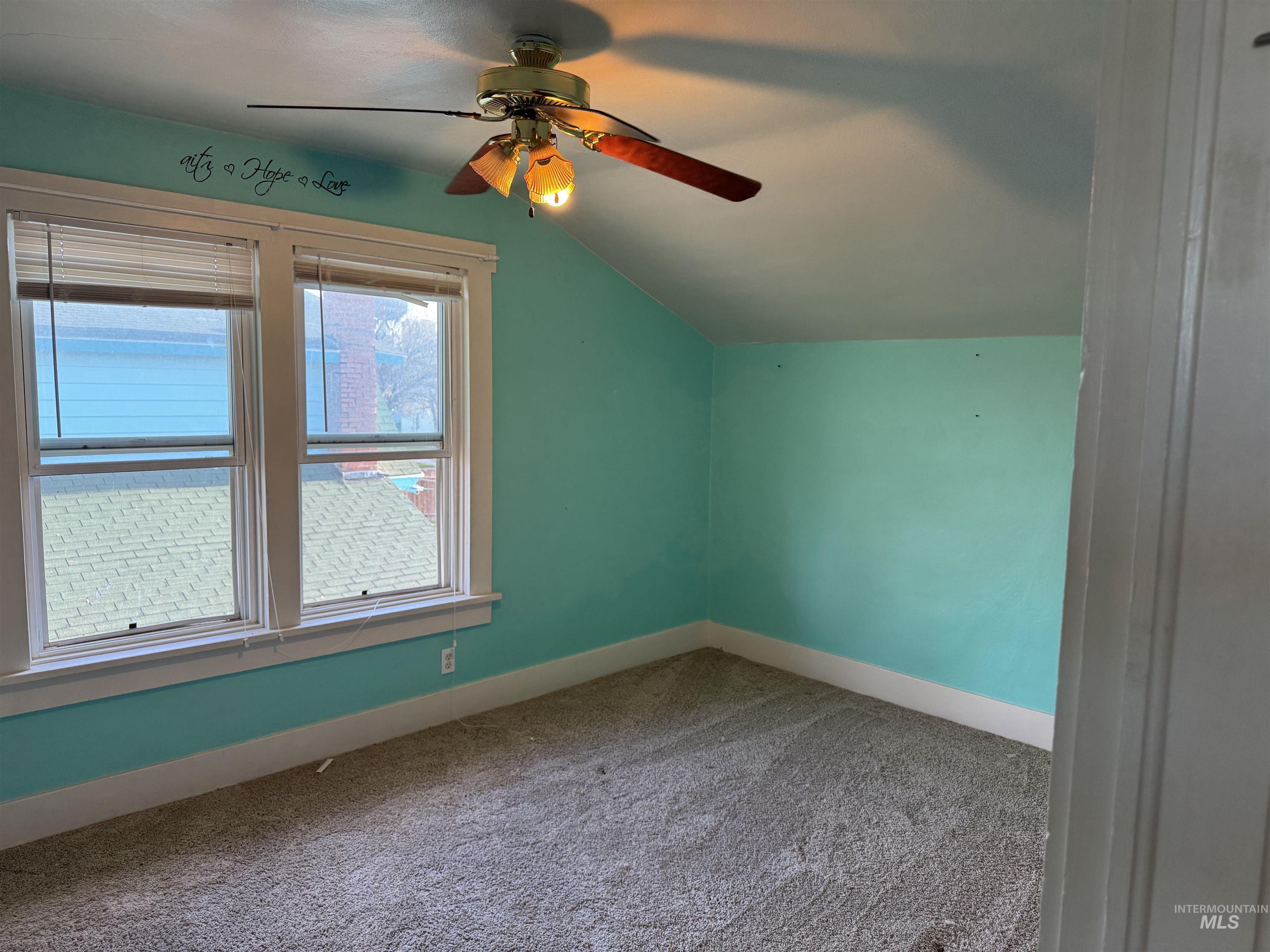 Bonus room with vaulted ceiling, carpet floors, and a ceiling fan