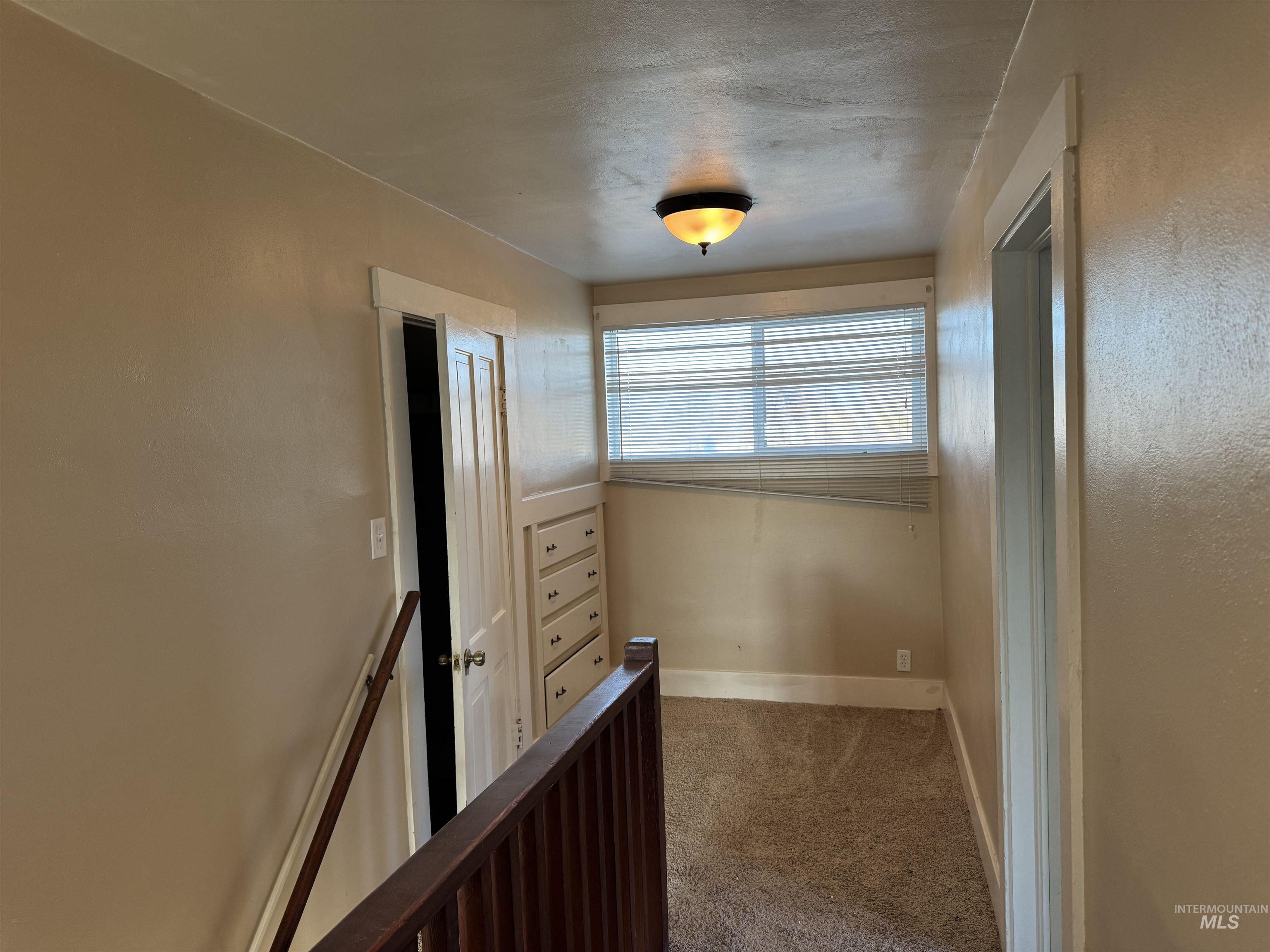 Corridor with carpet floors and baseboards