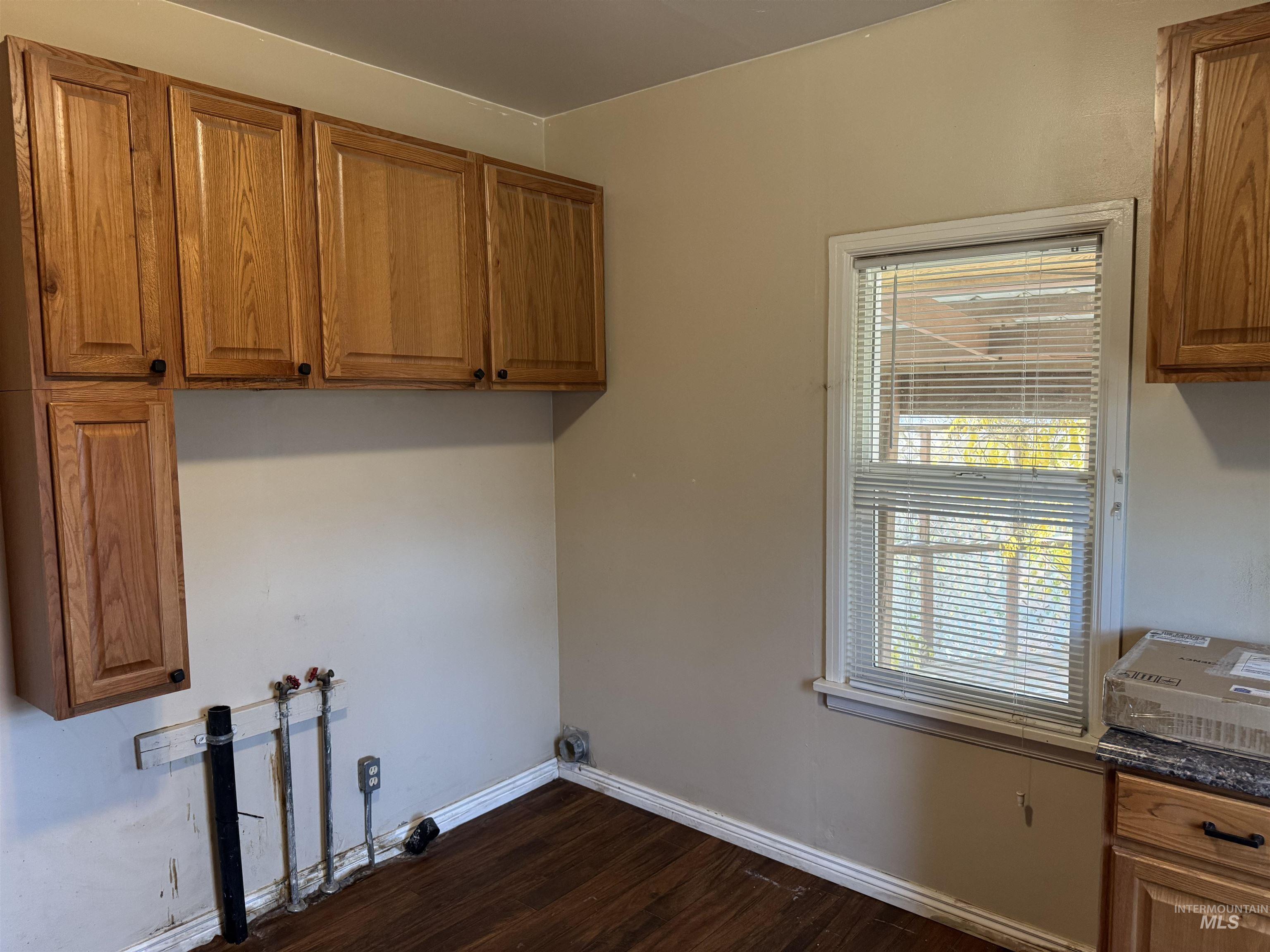 Washroom with cabinet space, dark wood-style floors, and washer hookup