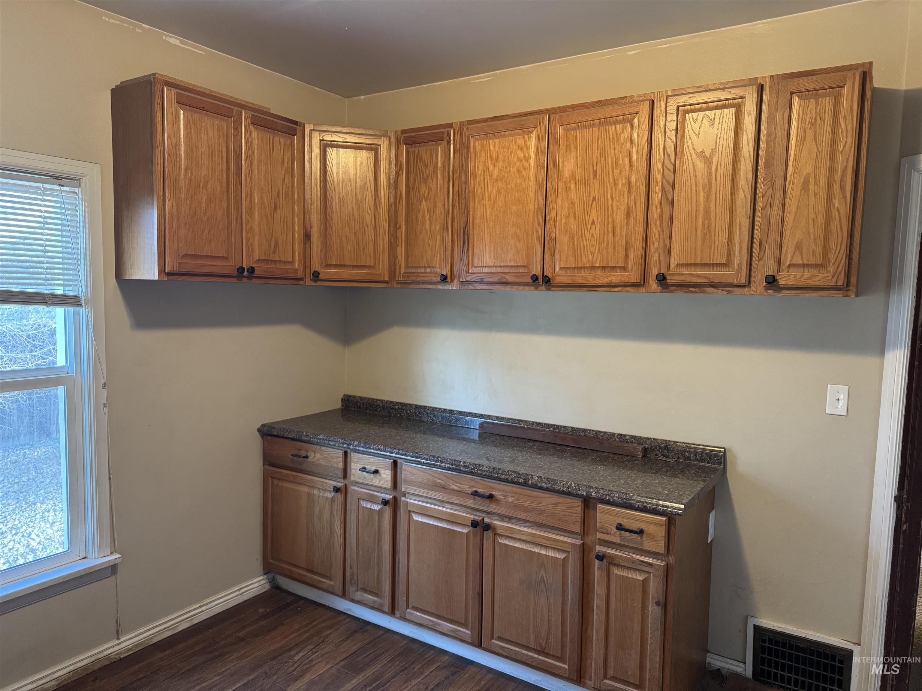 Kitchen with brown cabinetry and dark wood finished floors
