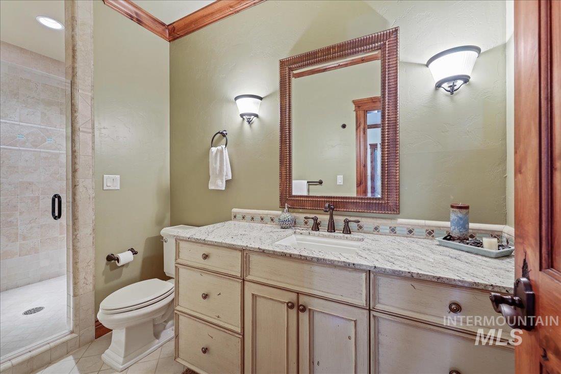 Full bath featuring a large tiled shower, vanity, and tile patterned floors