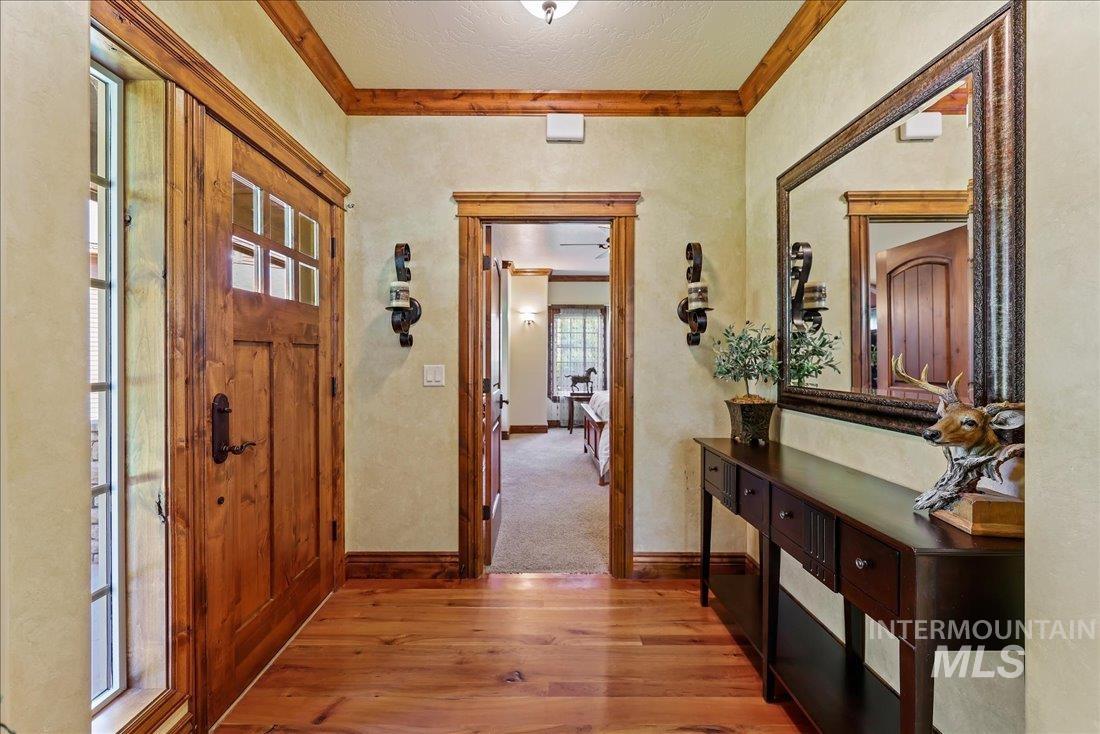 Entryway featuring crown molding and wood flooring