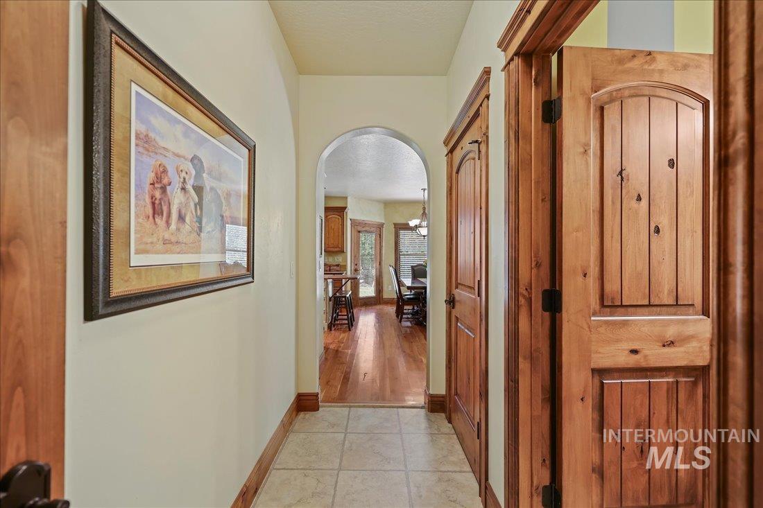 Corridor featuring arched walkways and wood floors