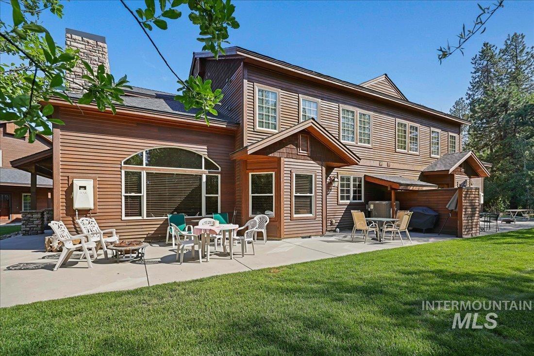 Rear view of house featuring a lawn, a patio, a fire pit