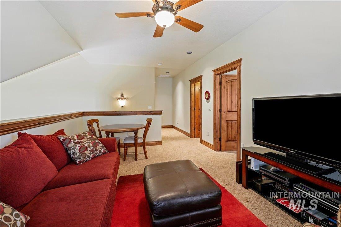 Living area with carpet and a ceiling fan